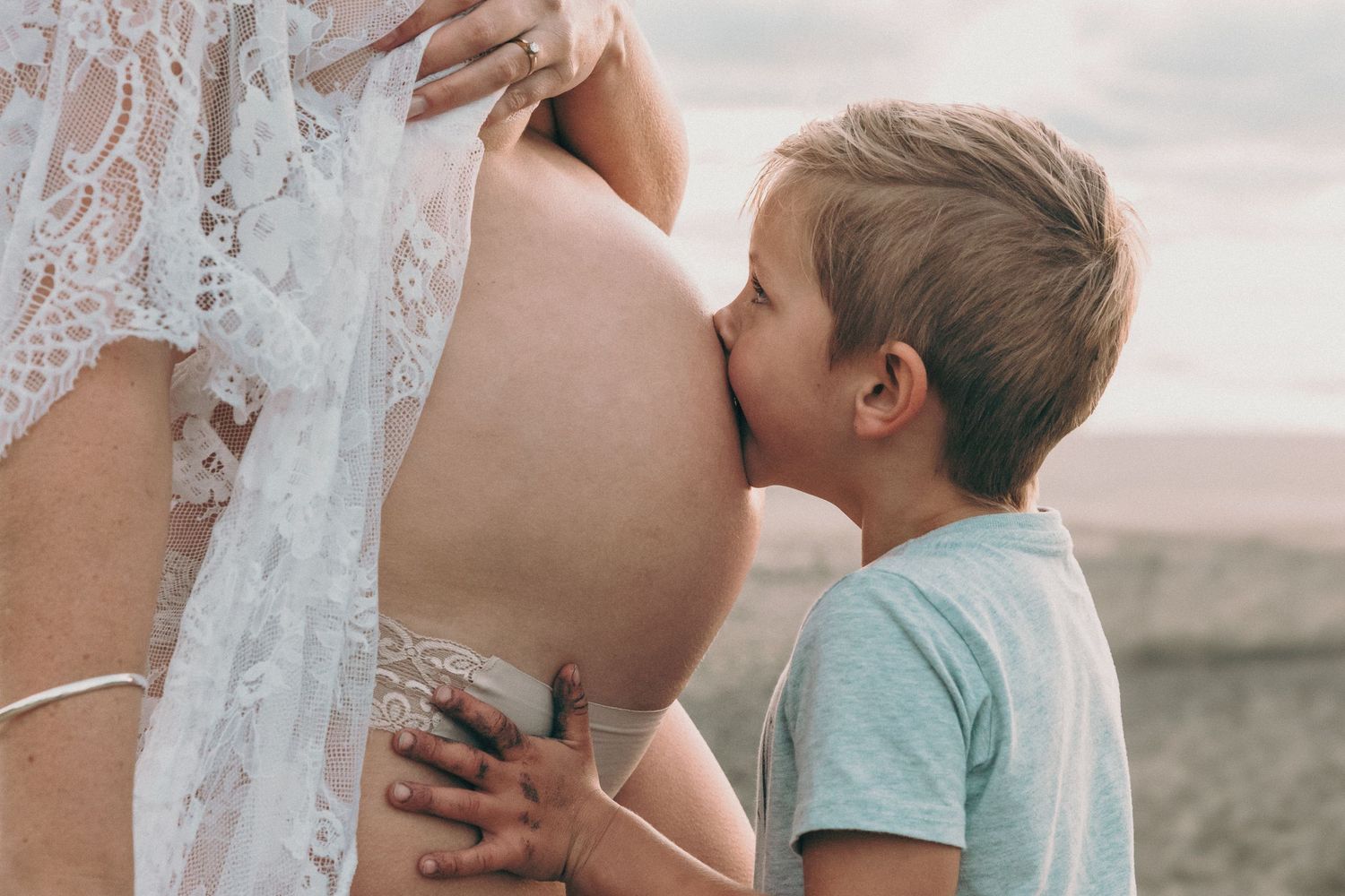 North Shore Maternity Photo: Son kissing mother's pregnant belly, captured by Auckland family photographer.