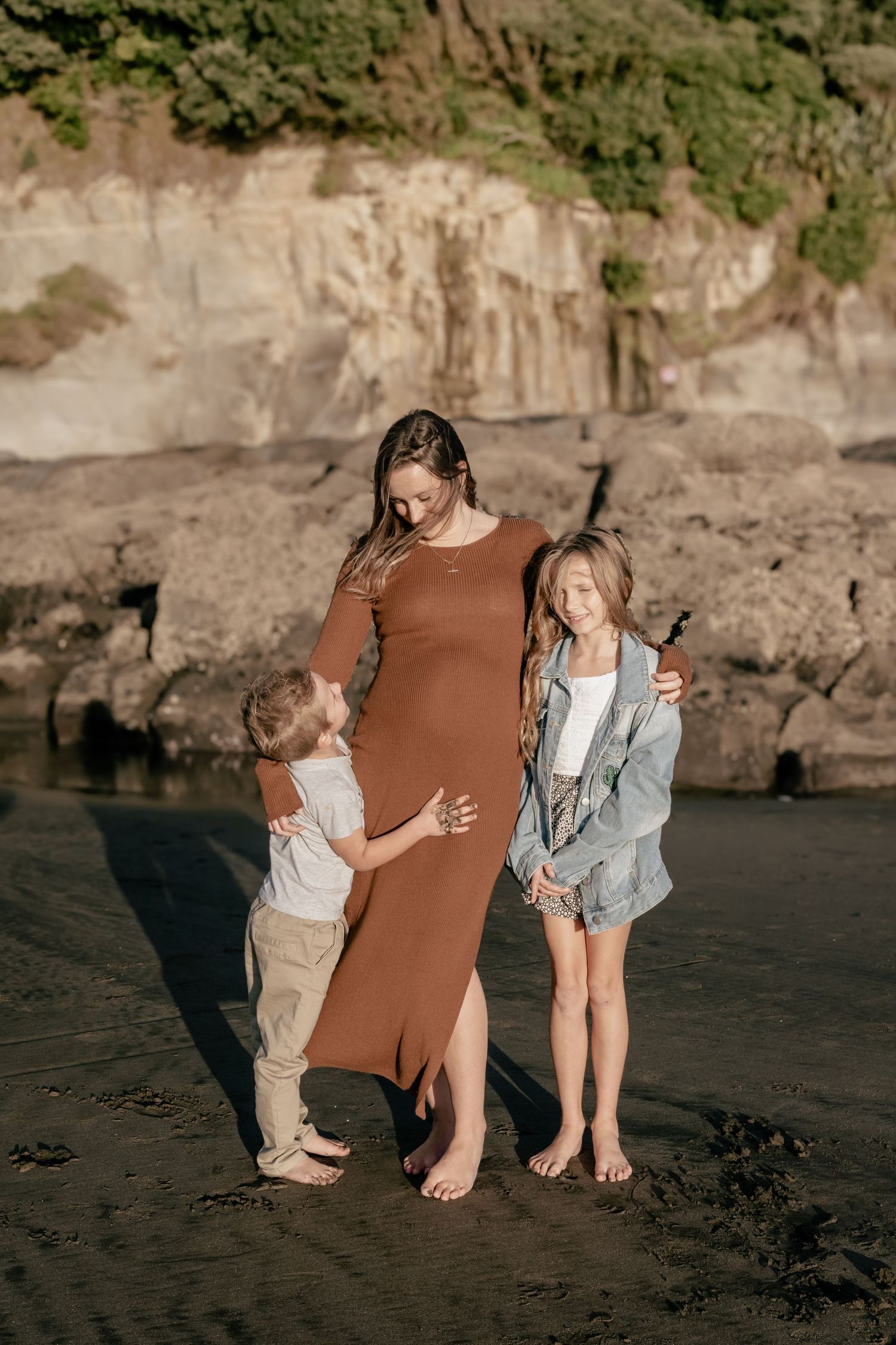 Muriwai Beach Family Maternity Session: Mum with two children posing on the beach, Auckland North Shore.