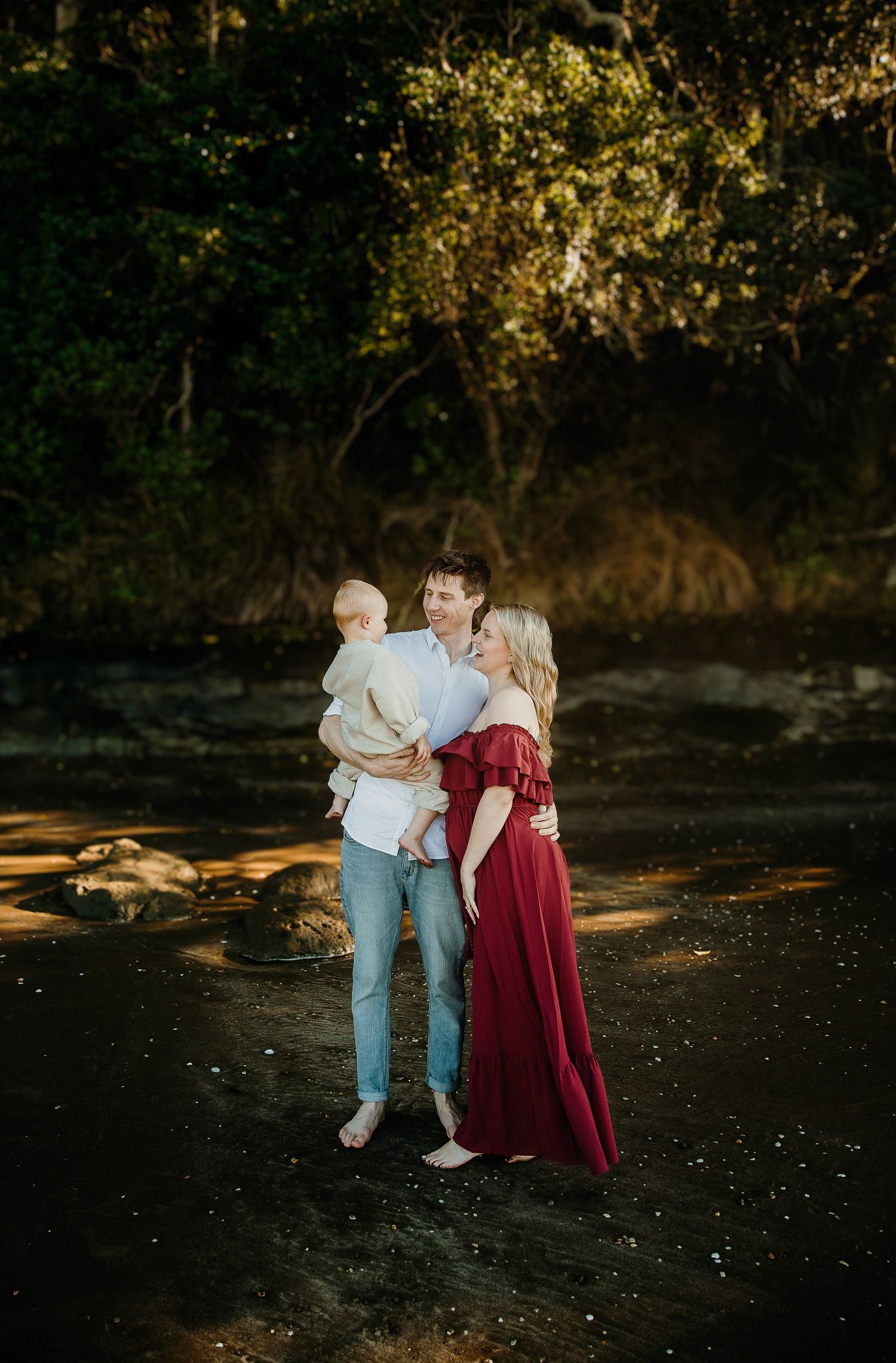 Long Bay Beach Maternity Session: Mum-to-be in red dress posing in golden light. Auckland photographer