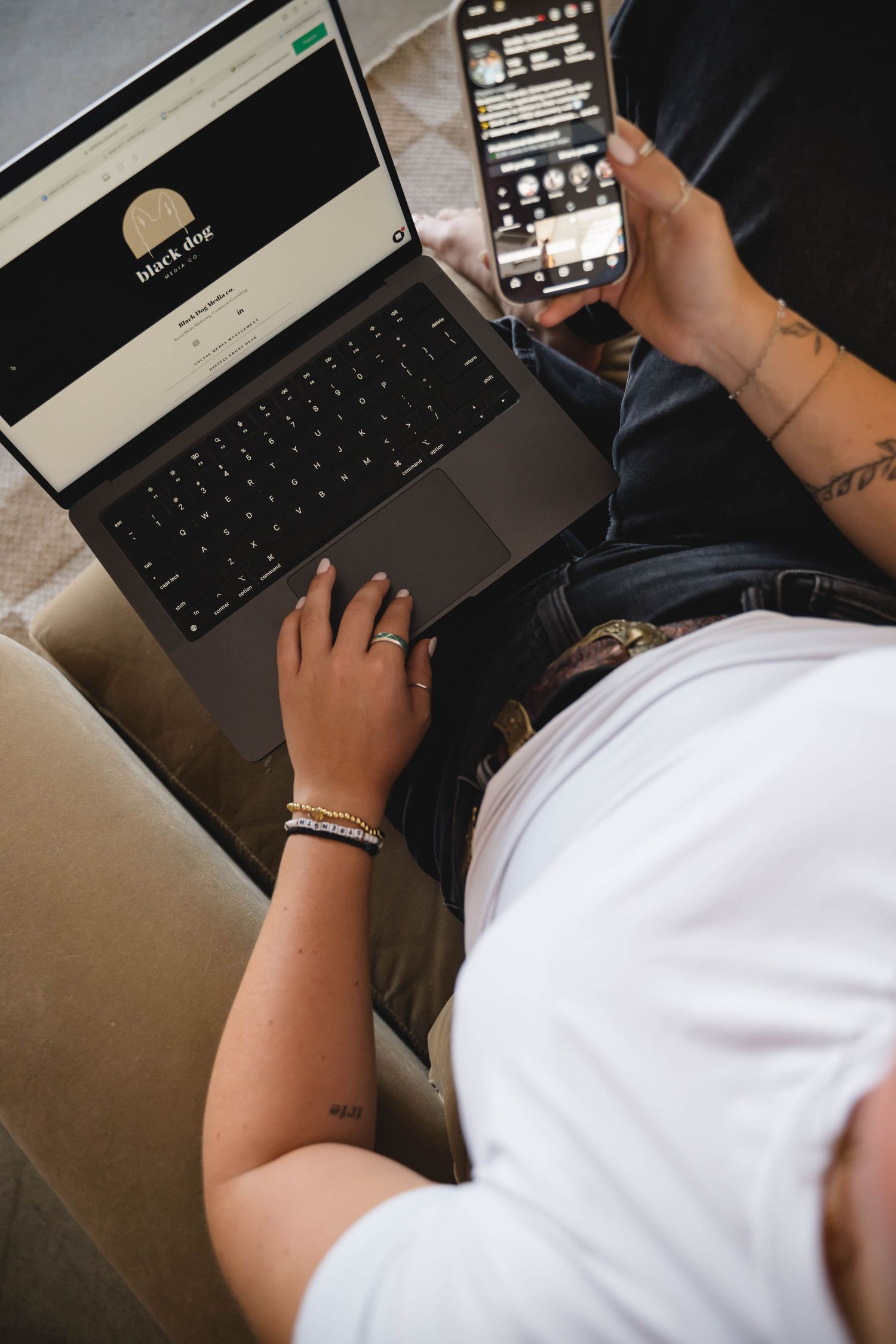 Person working on laptop with smartphone nearby, viewed from above.