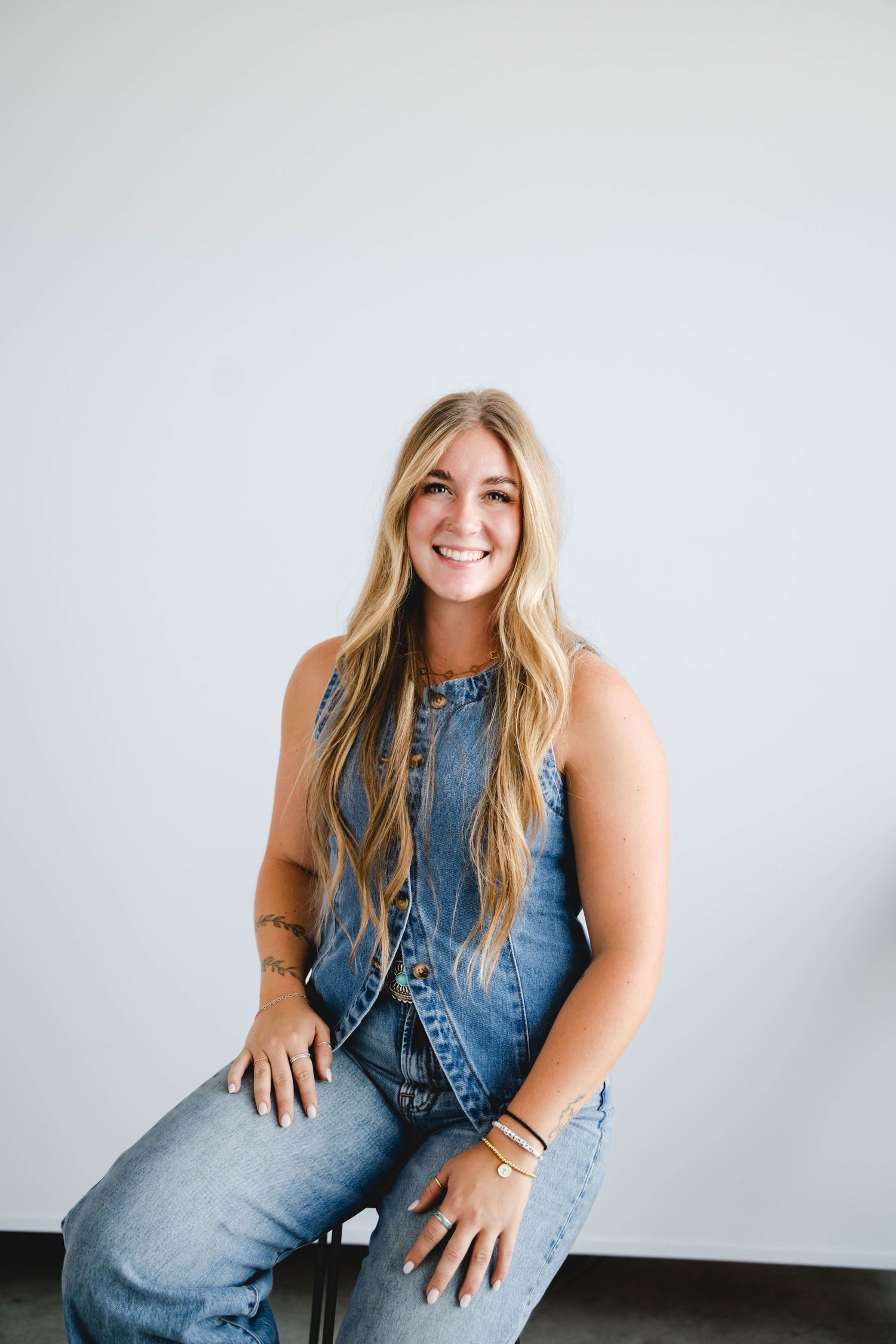 Emilie in denim overalls poses confidently against white background during studio session.