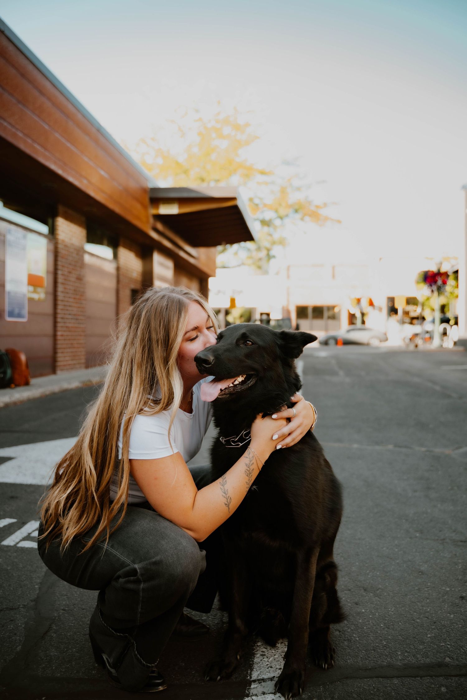 Emilie with Maverick outdoors in parking lot during sunset.