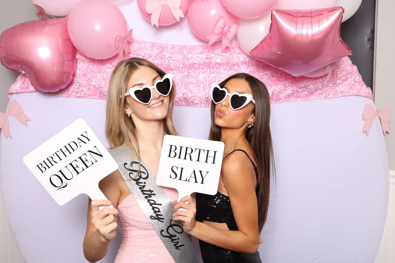 Group photo booth shots with fun props against a pink balloon backdrop.