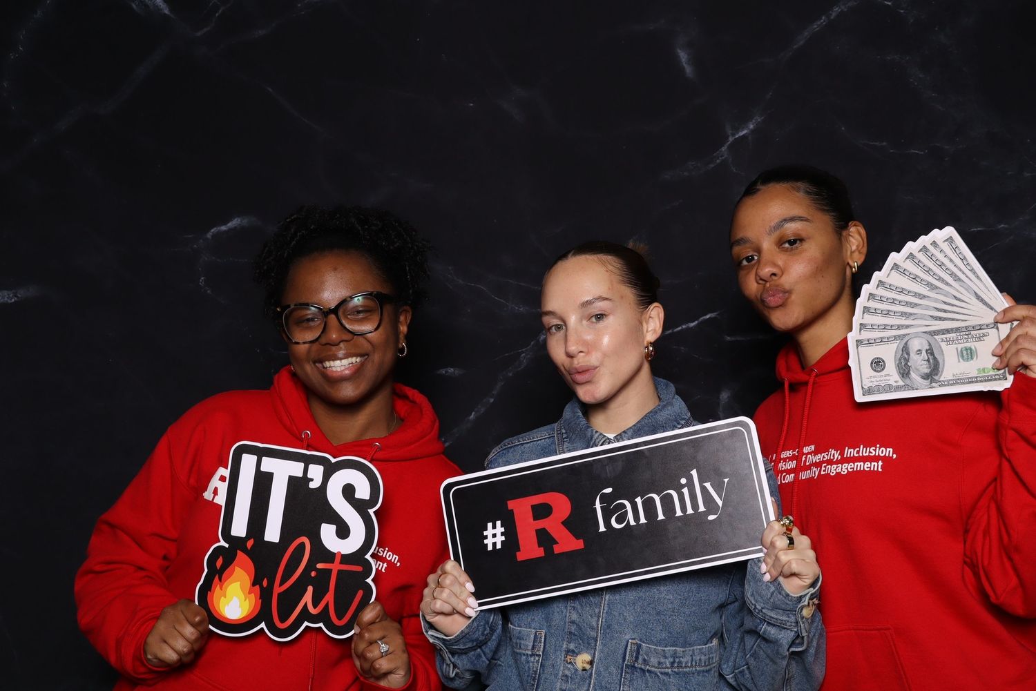 Group photo booth session with participants holding signs and props.