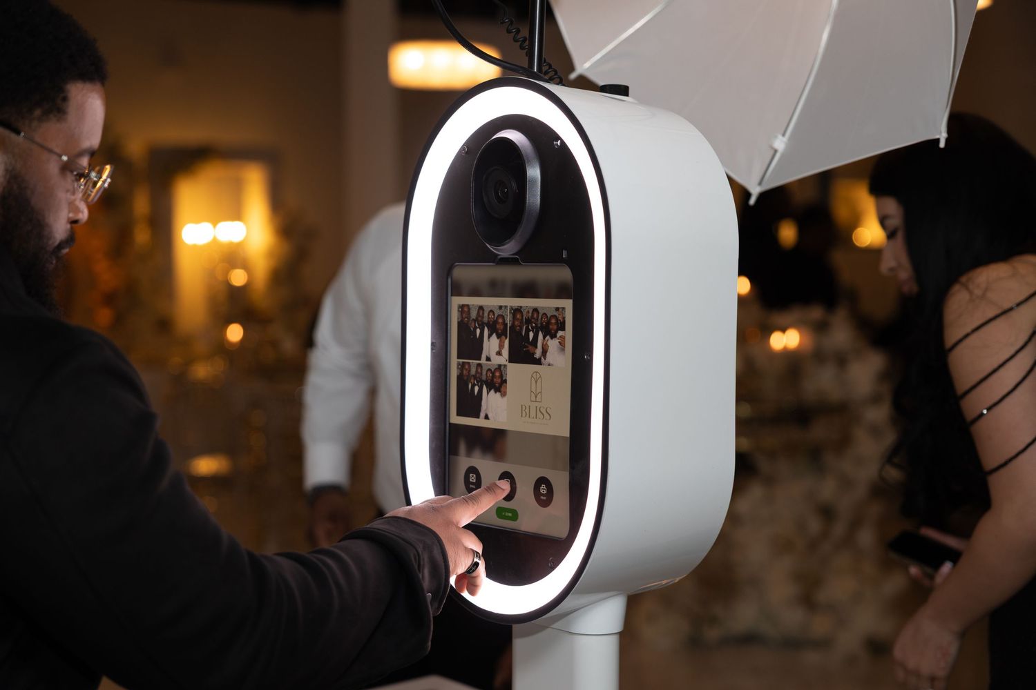 Close-up sequence showing a sleek white and black photo booth camera device with LED ring light.