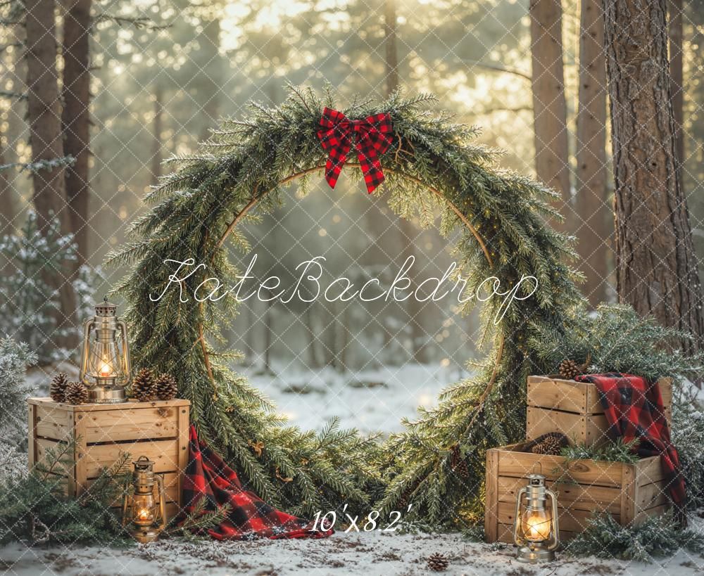 Christmas wreath backdrop with pine branches, red bow, lanterns, wooden crates, and snowy forest setting for holiday photos.