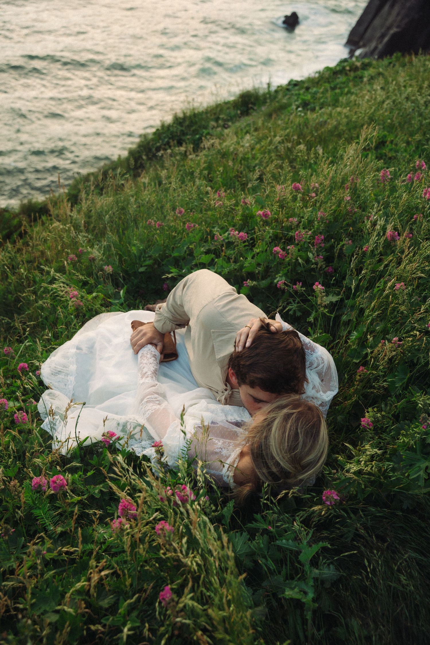Couple laying on the cliffs on the Oregon Coast for their elopement pictures