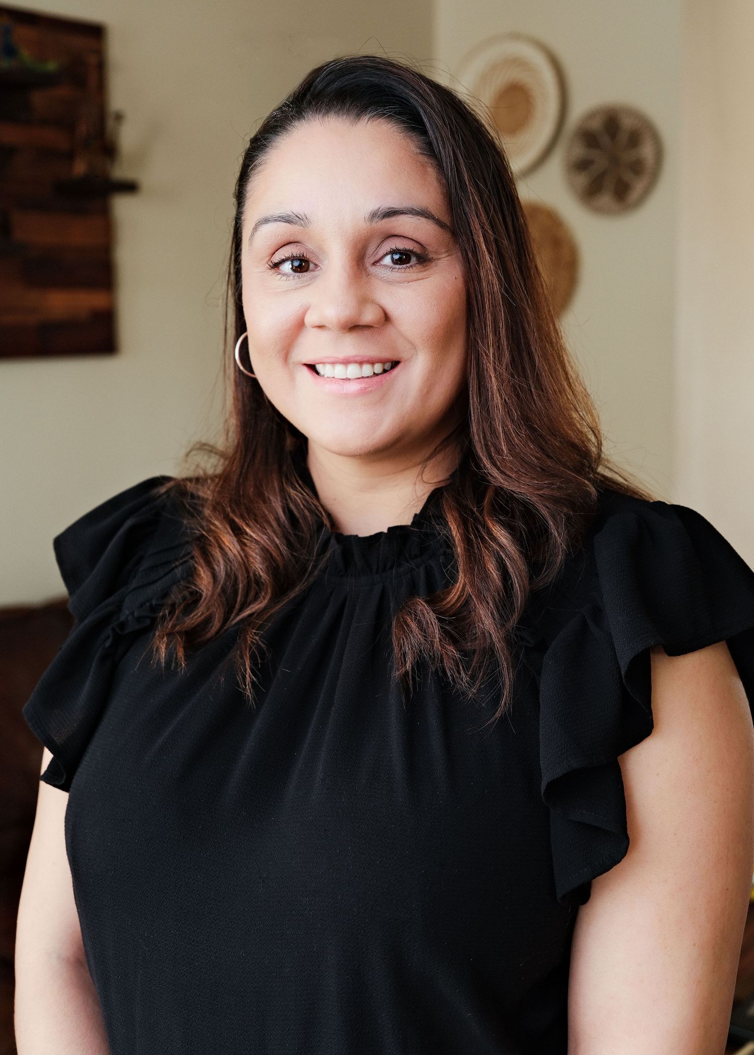 Professional headshot of a woman in a black top seated indoors
