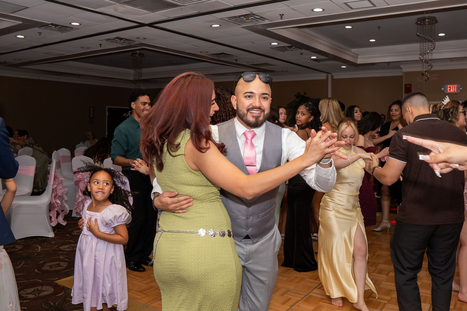 Couples dance together on the ballroom floor during a festive quinceañera celebration. Sweet 16!