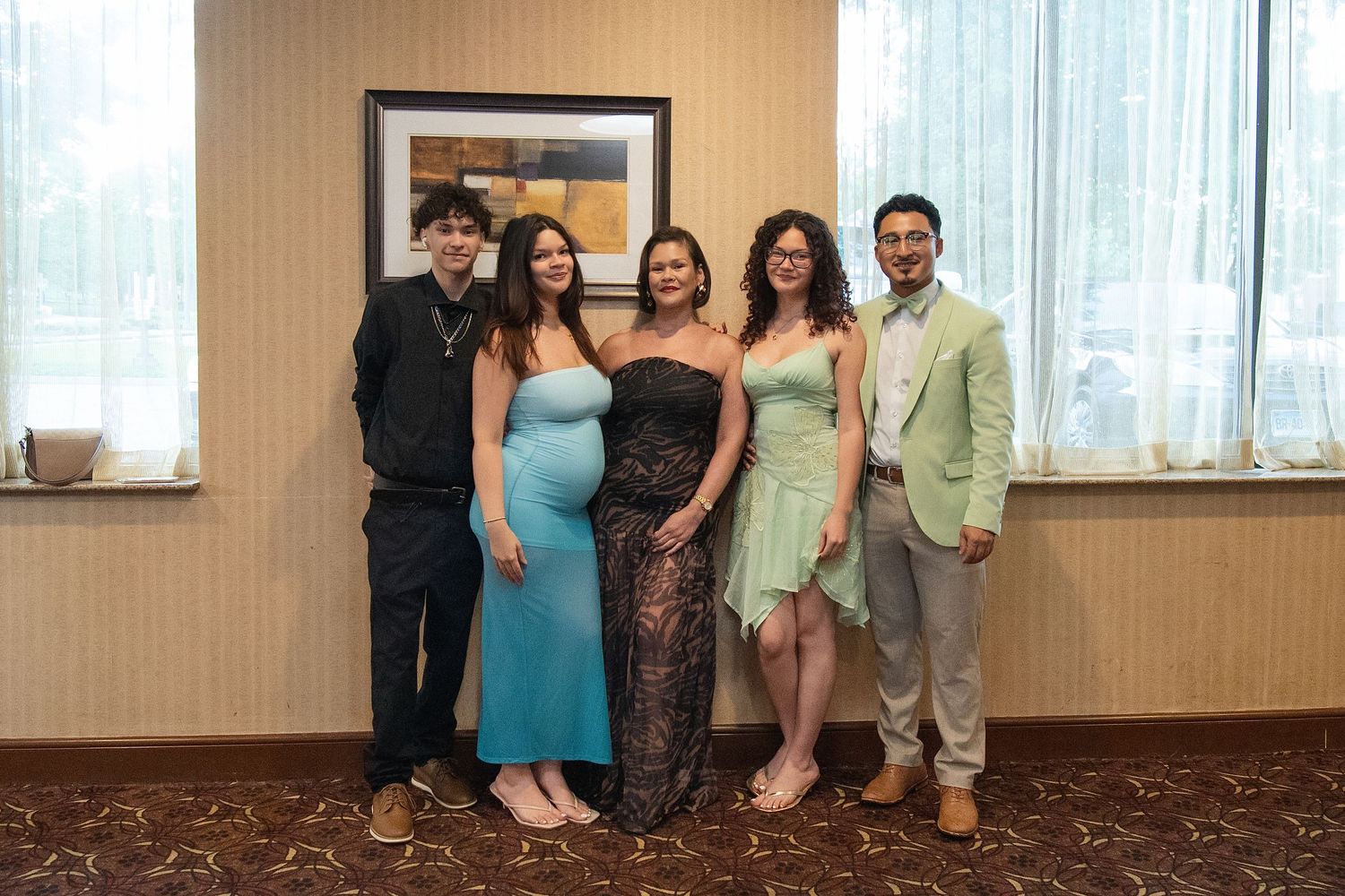 Group of five young adults dressed in formal attire posing together at a prom or gala event. Sweet 16!