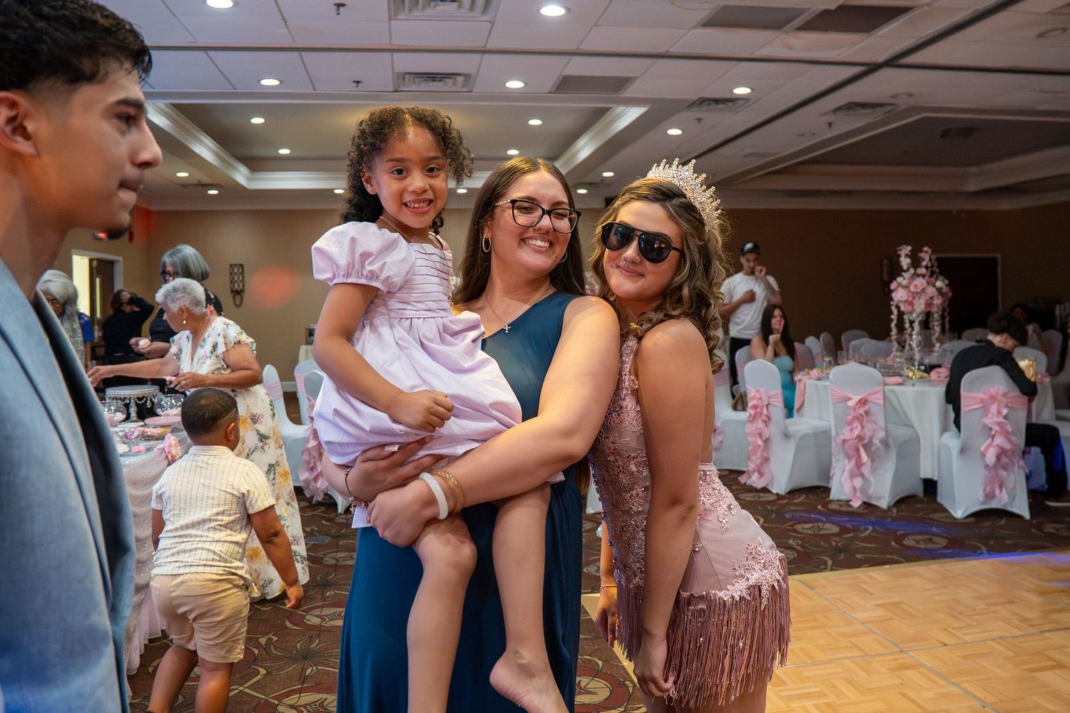 Women and child posing together at an elegant banquet hall celebration event. Sweet 16!
