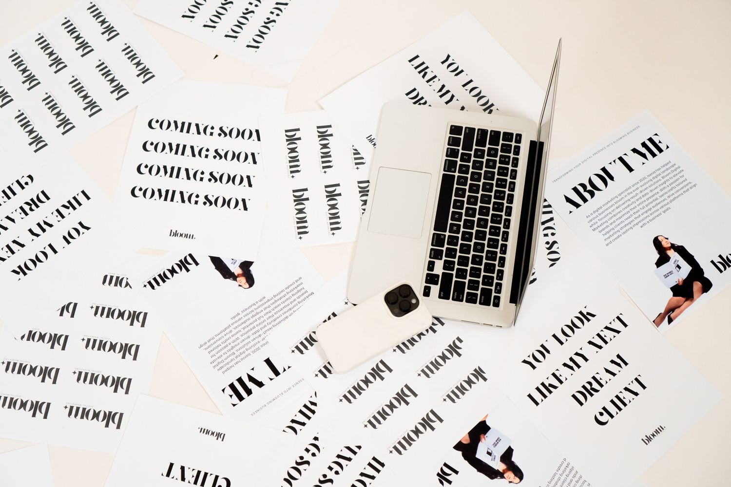Flat lay of business branding papers and laptop on white surface with coming soon and about me text.