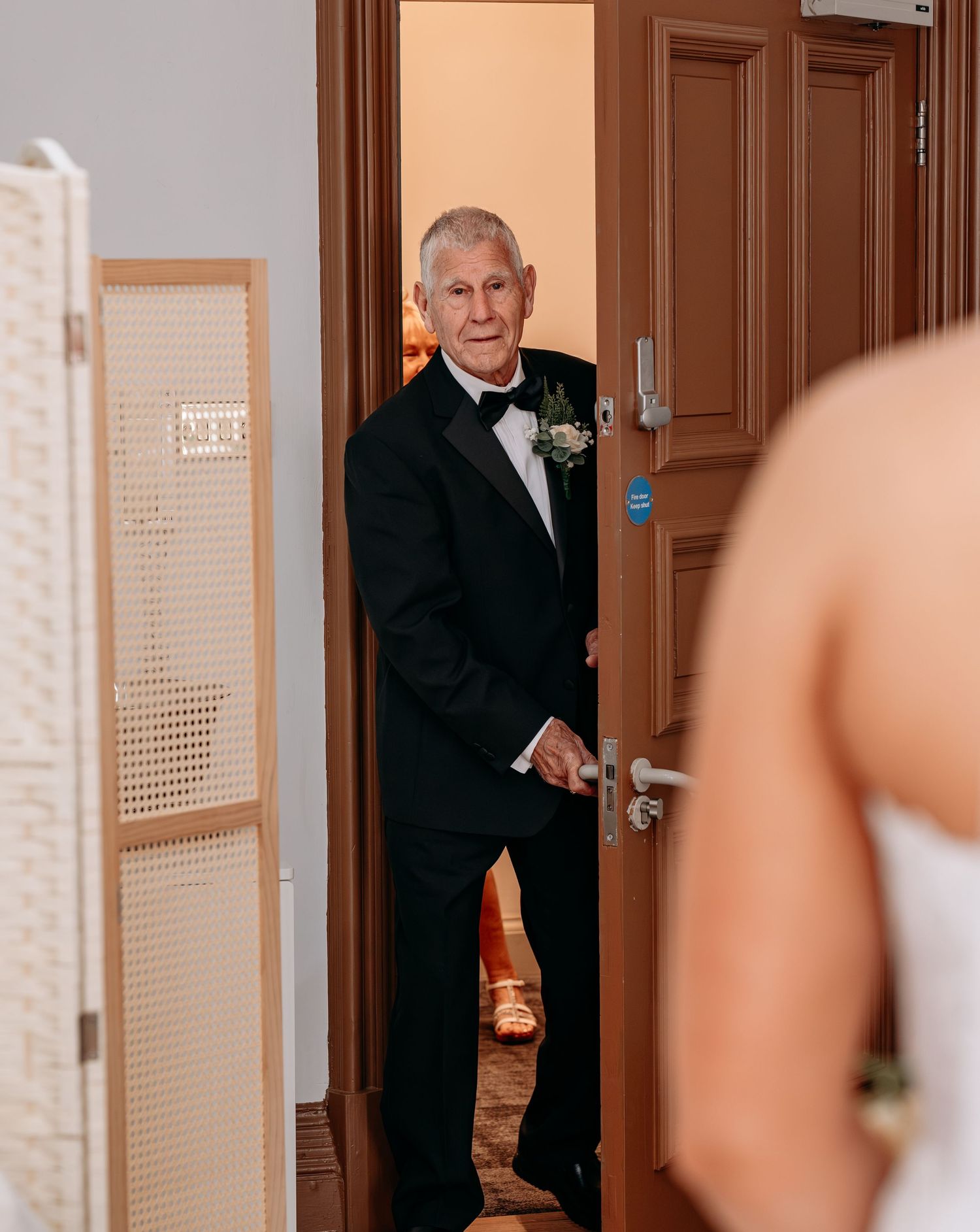 Father of the bride seeing his daughter in her wedding dress for the first time, emotional first look moment.