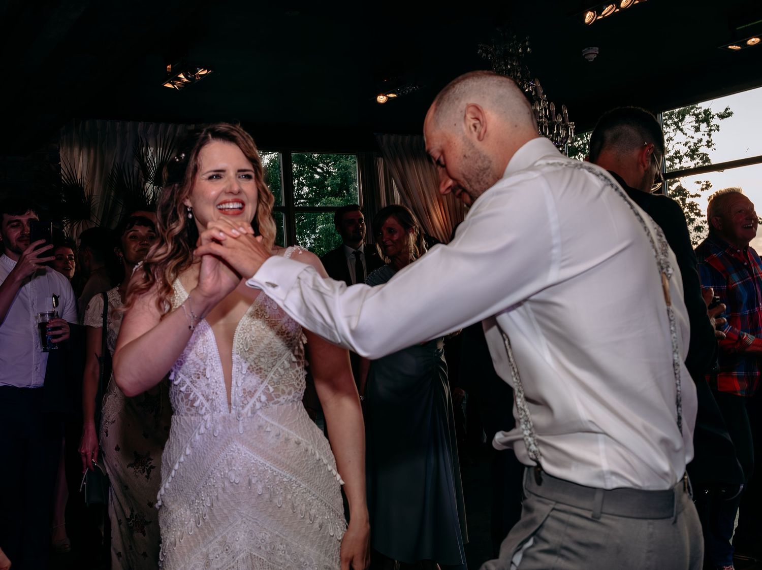 Bride and groom share a joyful first dance at their wedding reception in a lush outdoor venue.