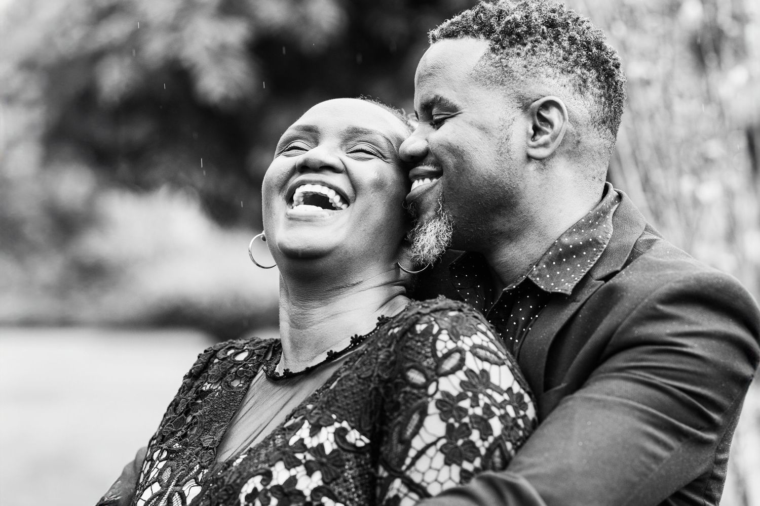 A Black couple embracing and laughing at Karen Blixen, Nairobi, Kenya. The image captures their joyful connection.