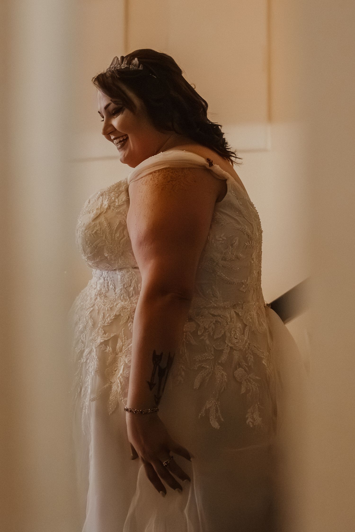A series of soft, romantic photos showing the back details of a white lace wedding dress in warm lighting.