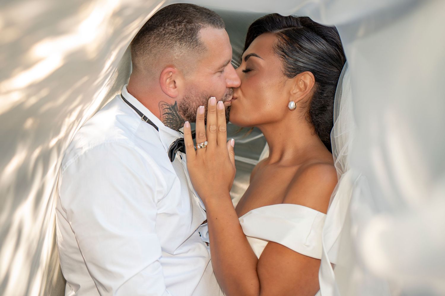 Romantic wedding couple portraits with soft lighting and intimate embraces against a light backdrop.