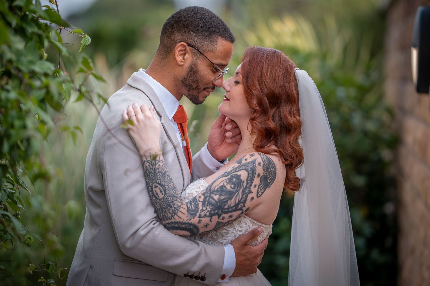 Intimate garden wedding portrait with white dress and light grey suit.