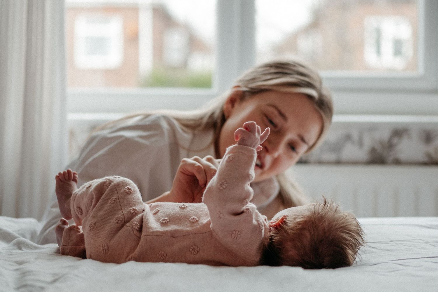 Woman smilles at newborn baby during her newborn baby photoshoot in Gosforth