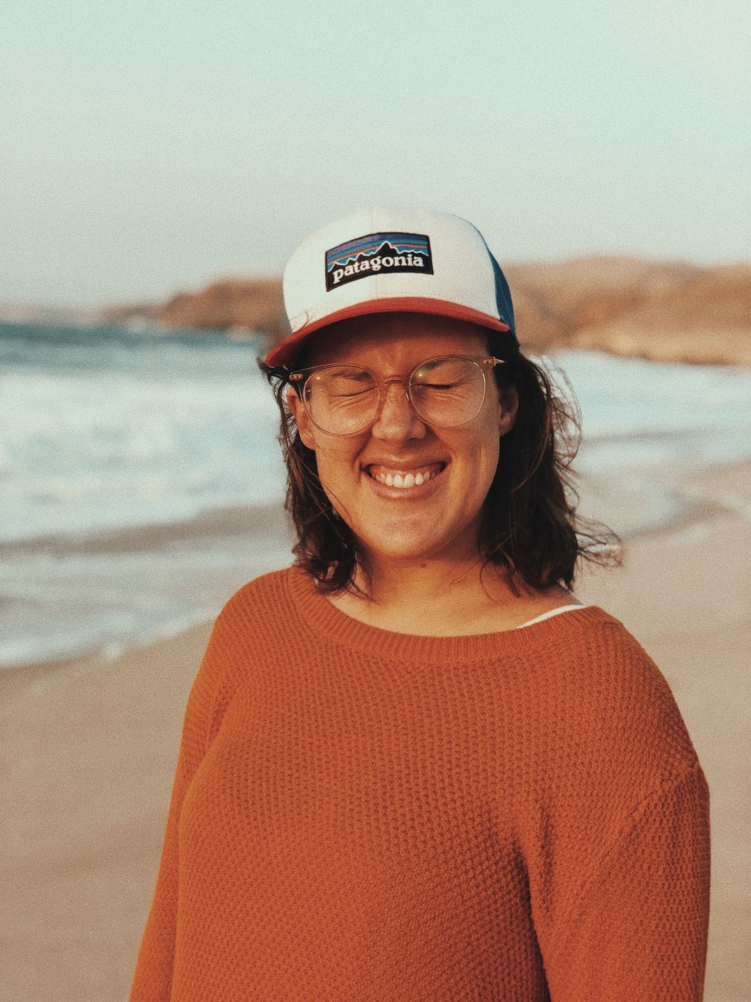 Girl on beach wearing hat and smiling