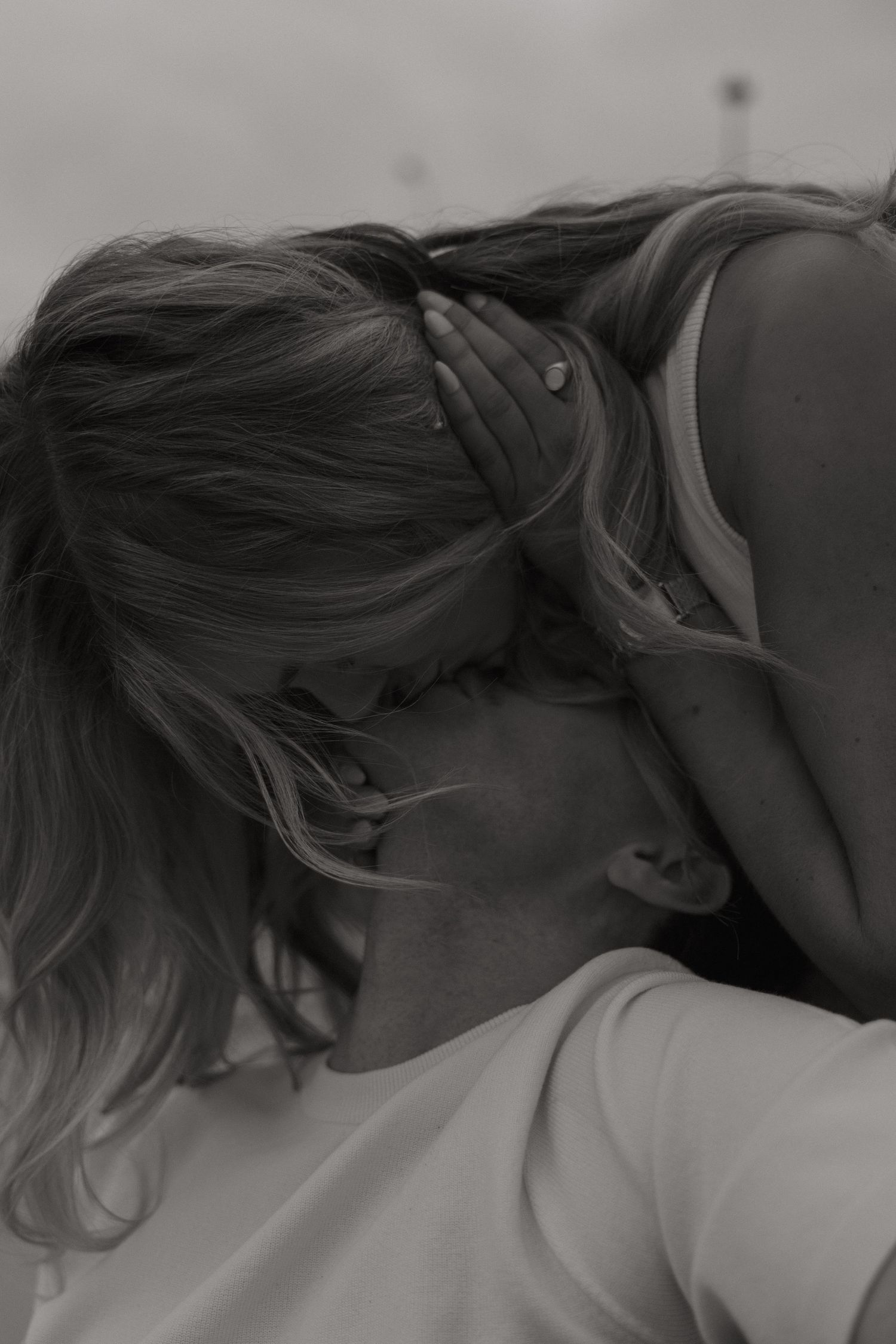 Black and white close-up of a romantic couple sharing a tender kiss outdoors.