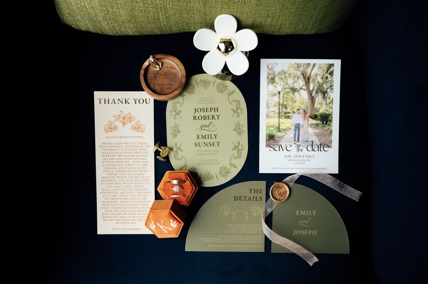 Elegant wedding stationery suite with sage green invitations, thank you cards, save the date, and wax seal on dark background.