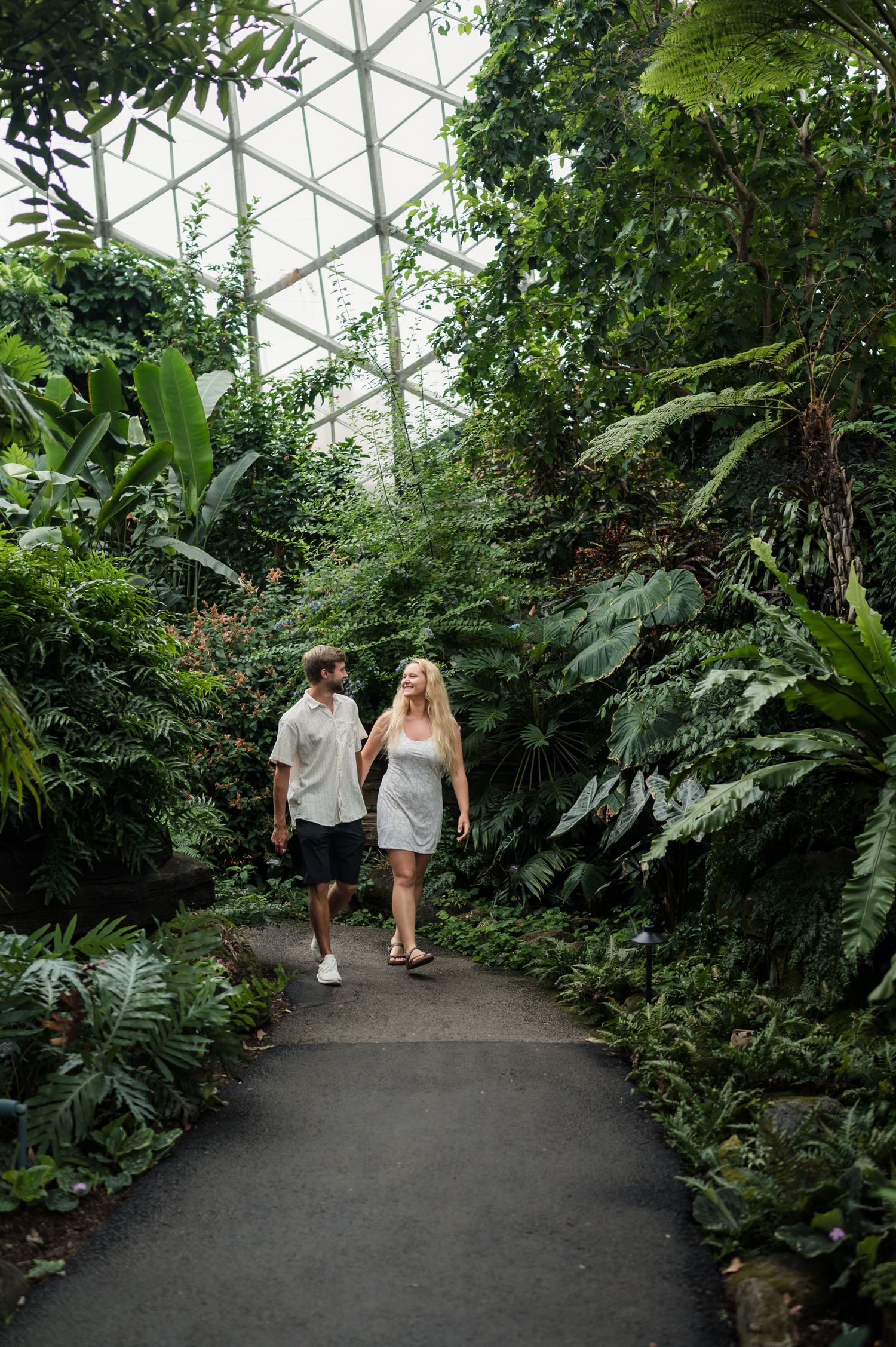 Couple walking hand in hand through the Mitchell Park Domes in Milwaukee, Wisconsin.