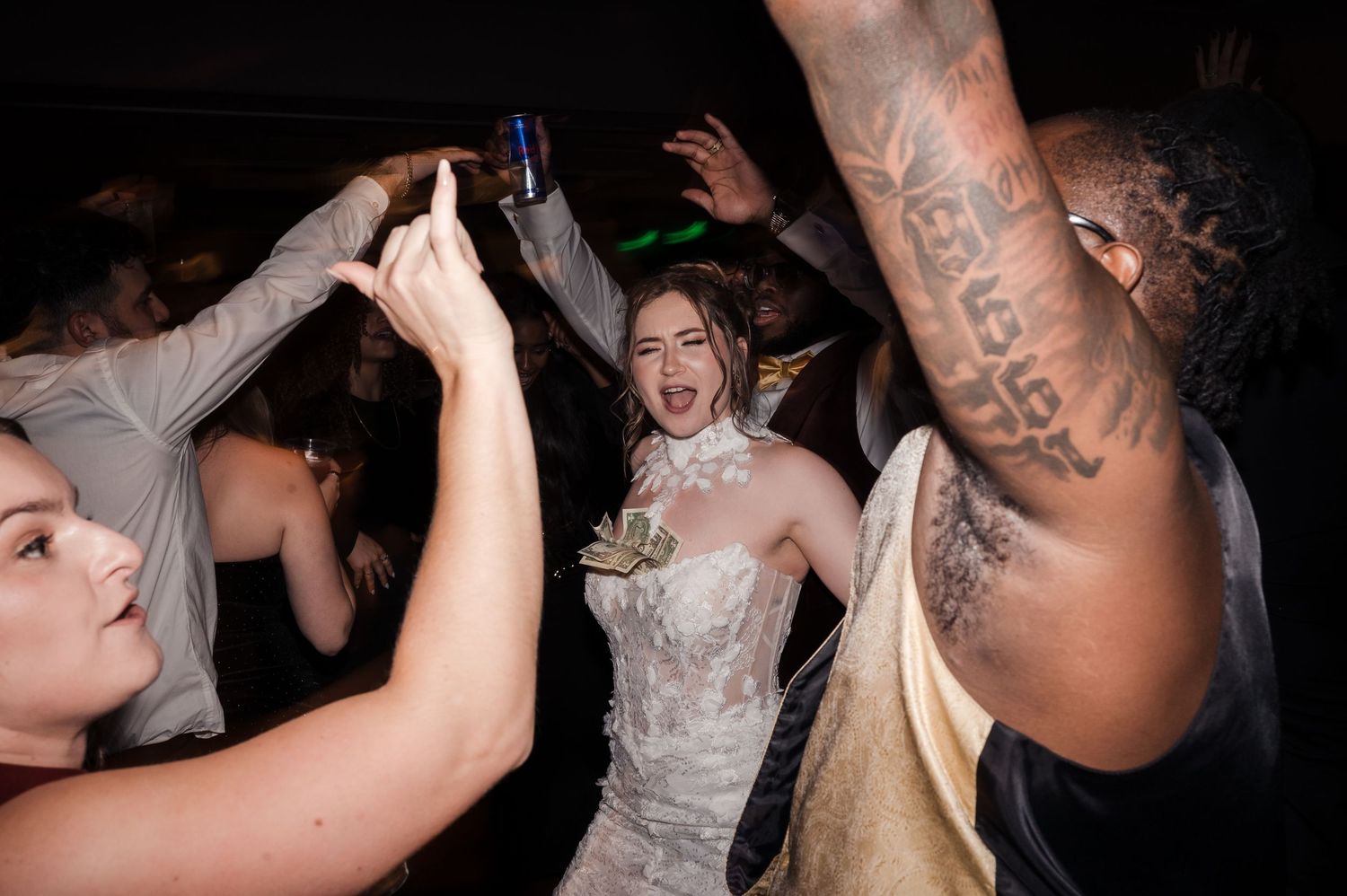 People enjoying drinks and socializing at a nightclub party with dim lighting and energetic atmosphere.