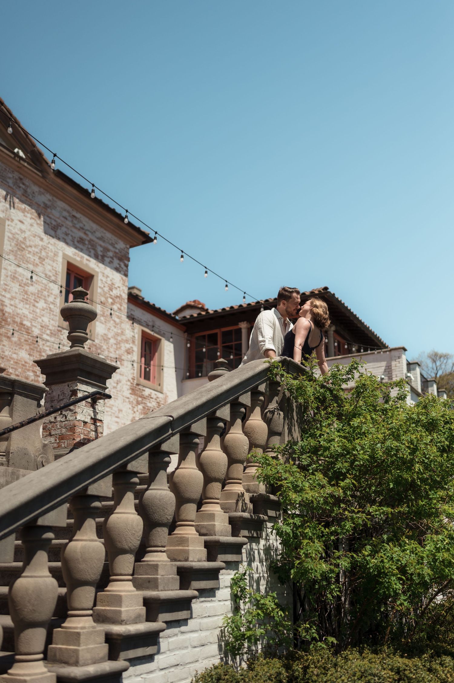 Couple kissing on ornate stone staircase at Villa Terrace in Milwaukee, Wisconsin.