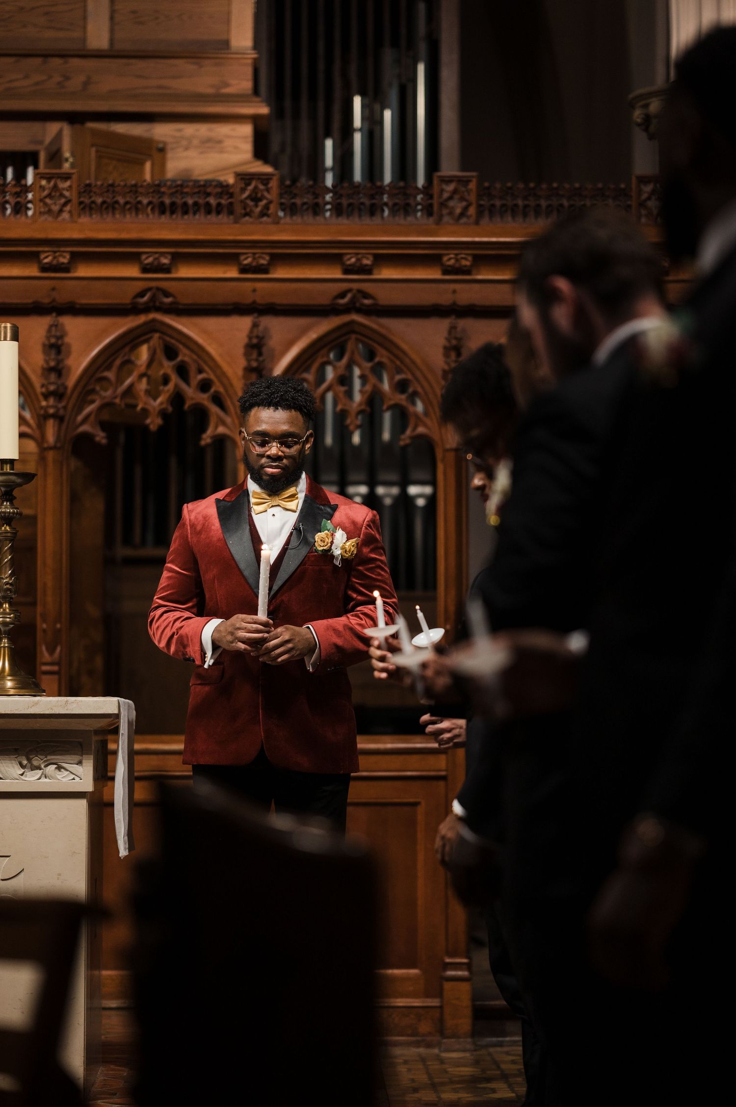 A person in a red blazer stands at a wooden church podium during a service.
