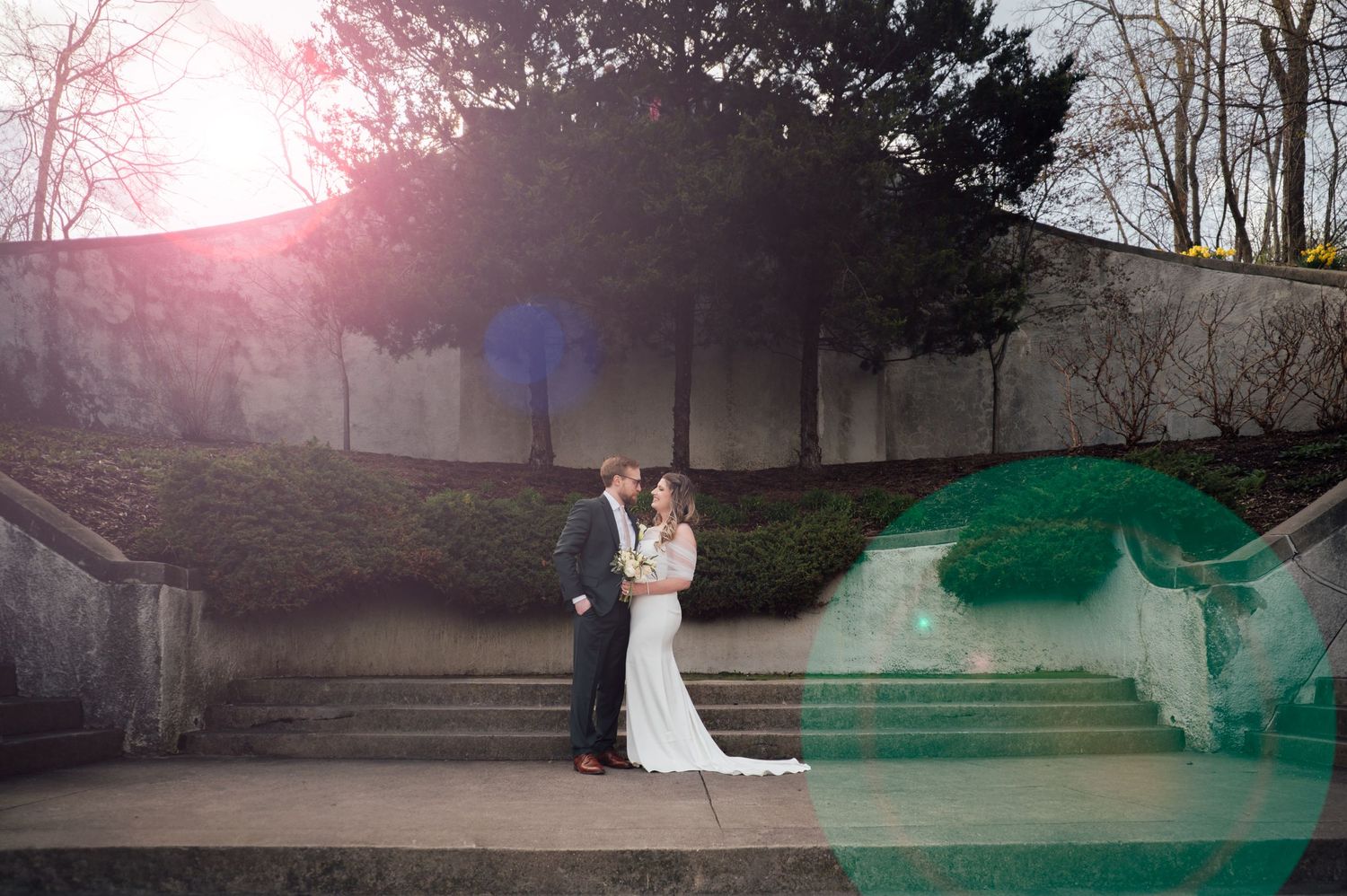 Bride and groom share a romantic moment on stone steps at sunset in an outdoor wedding portrait.