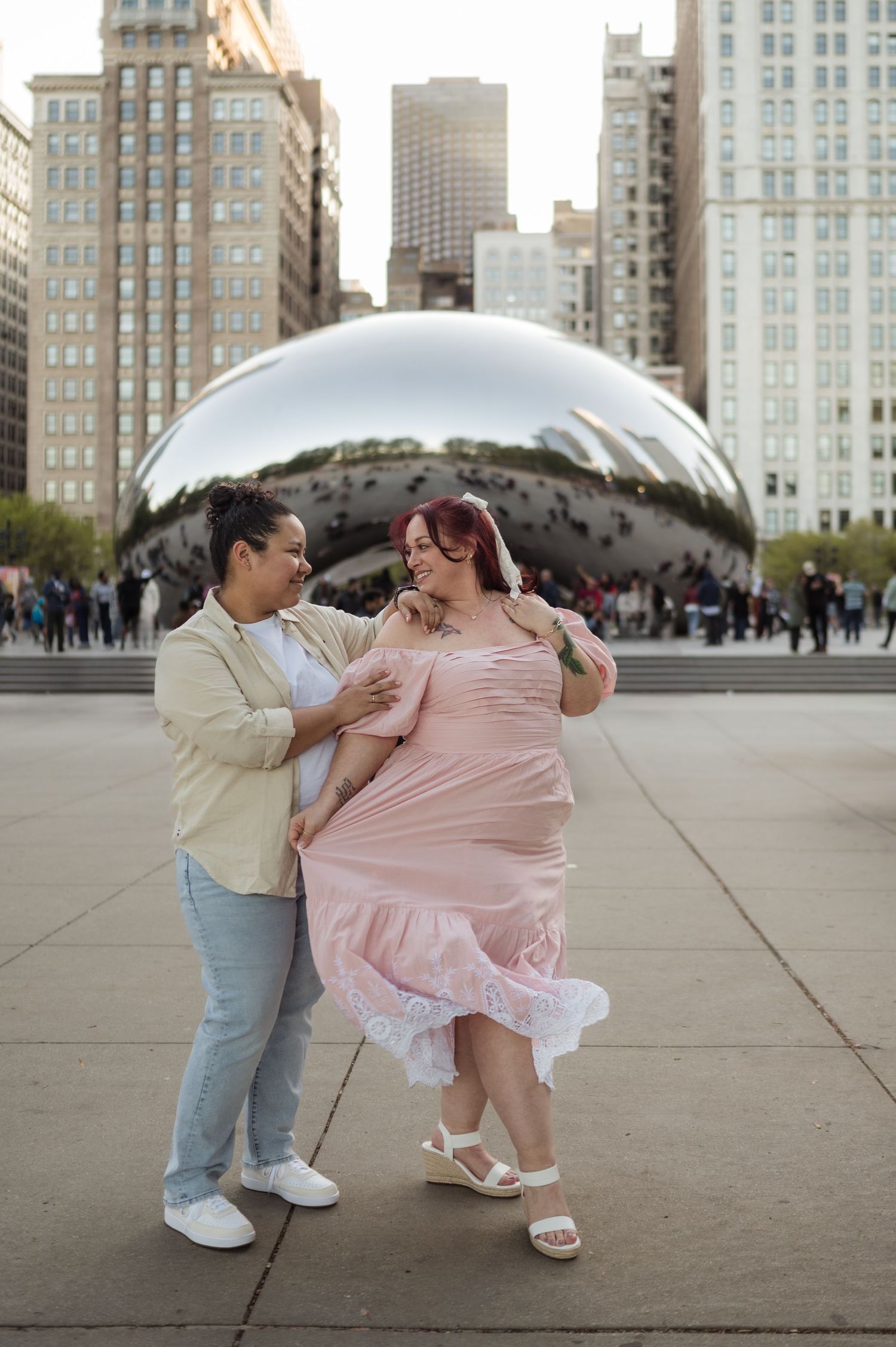 Couple dancing joyfully in front of Cloud Gate Bean sculpture in Chicago Millennium Park.