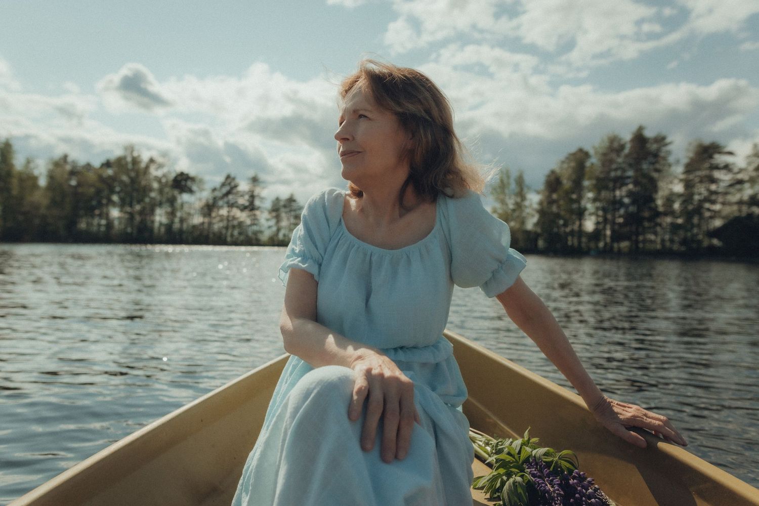 Nainen veneessä järvellä, kesäinen päivä ja rauhallinen, merkityksellinen hetki
