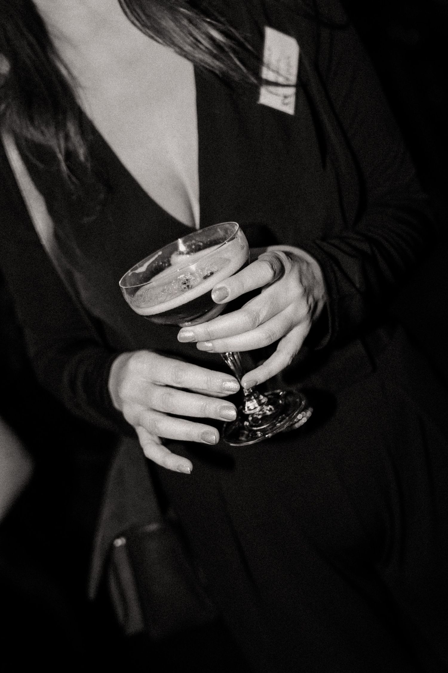 une invitée qui tient une coupe de cocktail dans la main