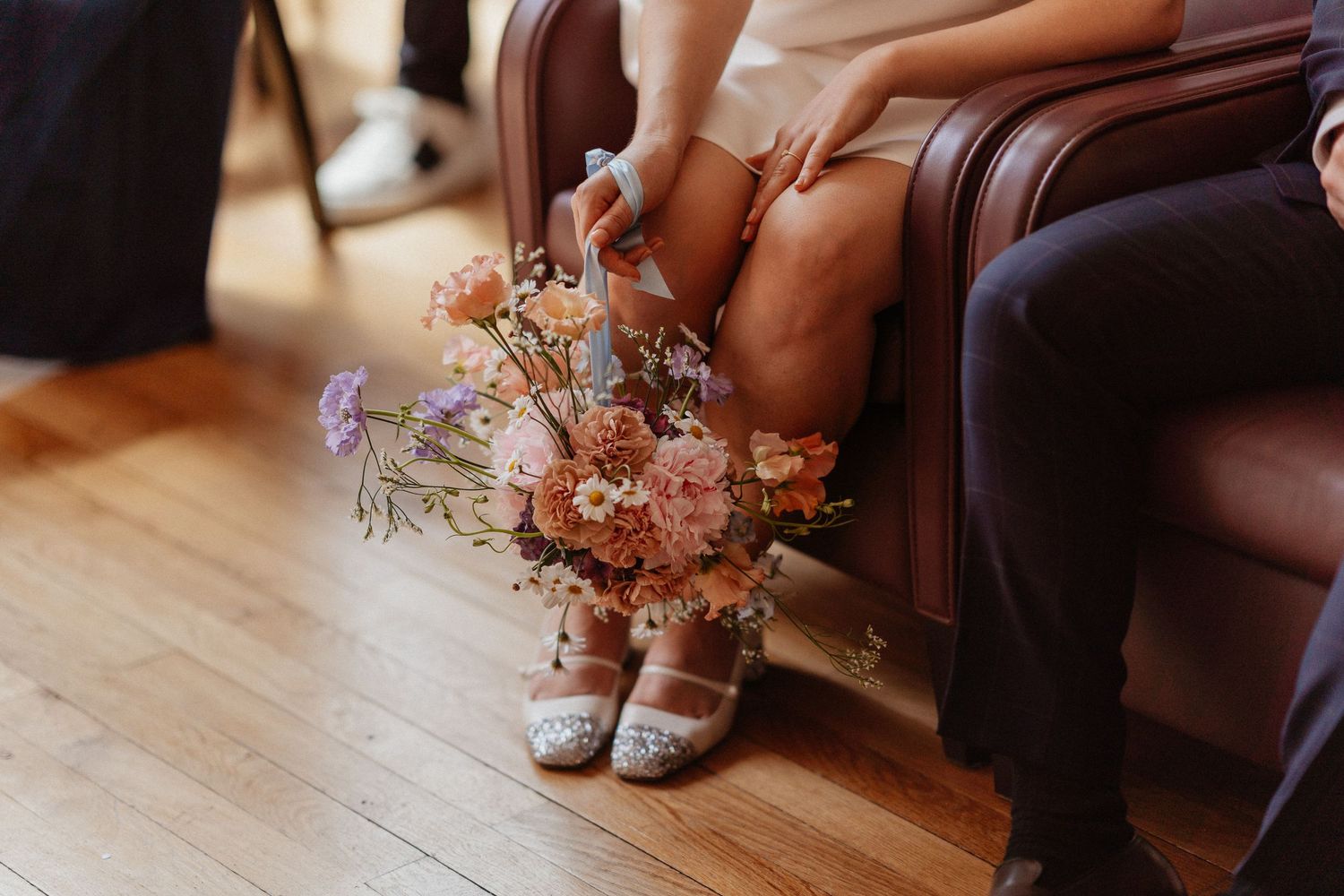 un bouquet de fleurs pendant le long des jambes de la mariée