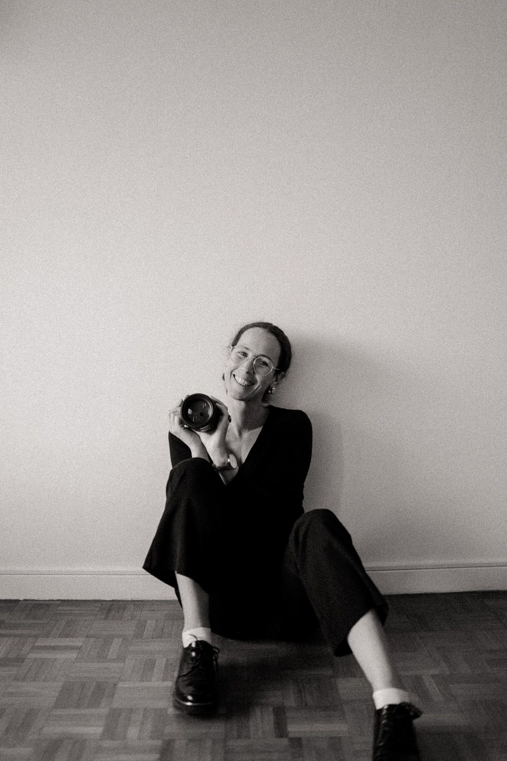 une femme qui sourie avec un appareil photo dans les mains
