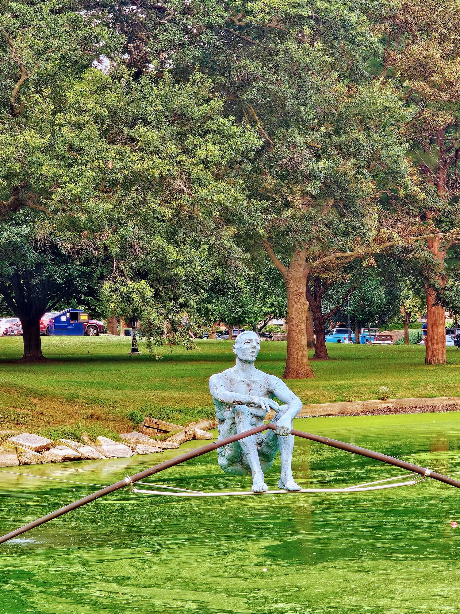 The Umbrella Rider statue in the pond at Schiller Park in German Village Columbus Ohio