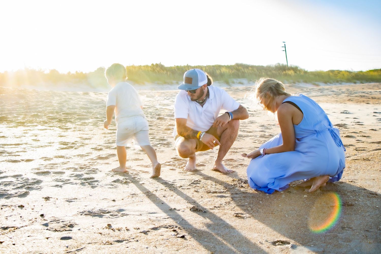 A family of three looking for seashells on the beach in Florida during the golden sunset hour with beautiful lighting.