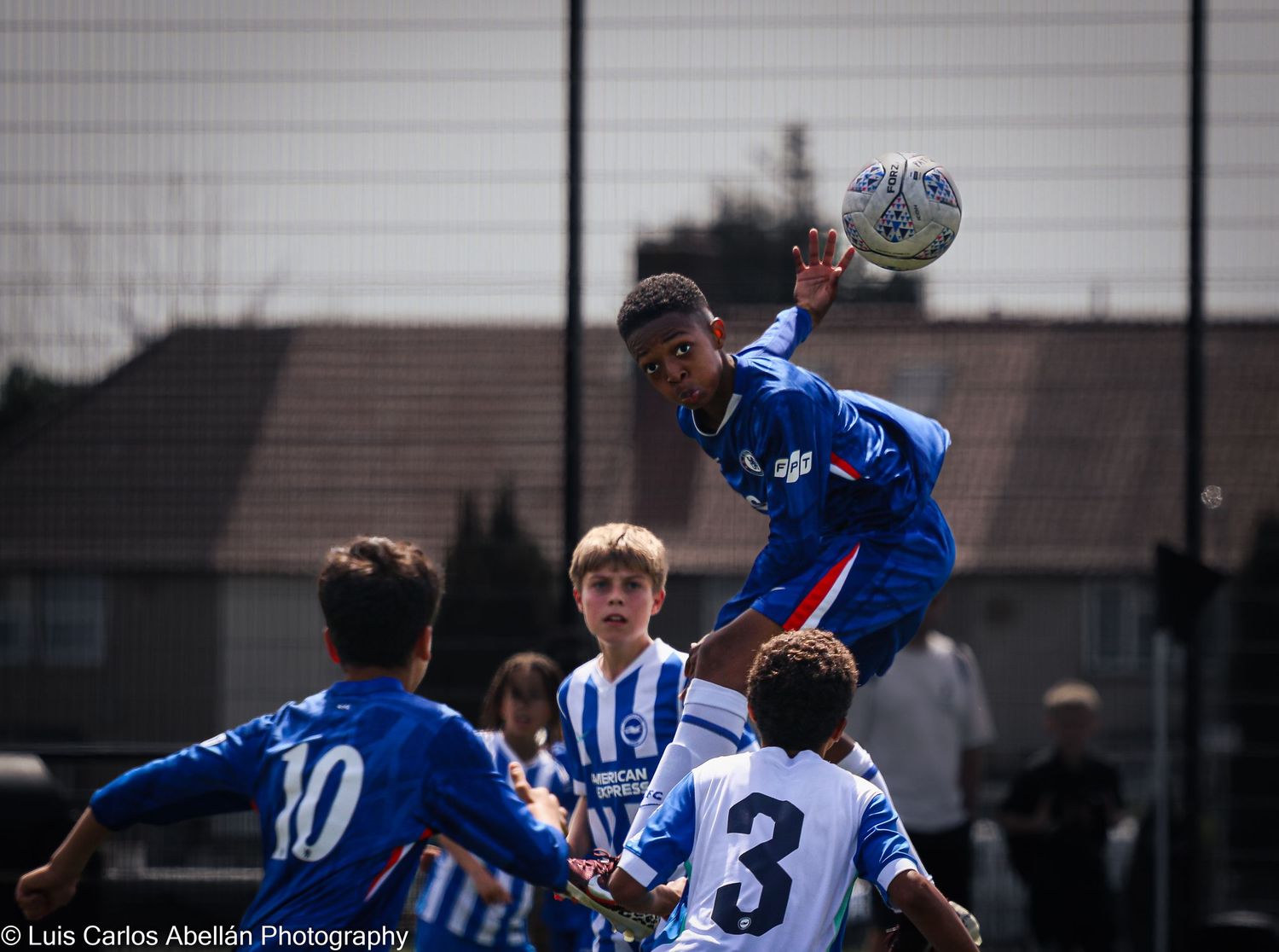 A young football player jumps to head the ball in a youth match, shot by South East England sports photographer Luis Carlos Abellan.