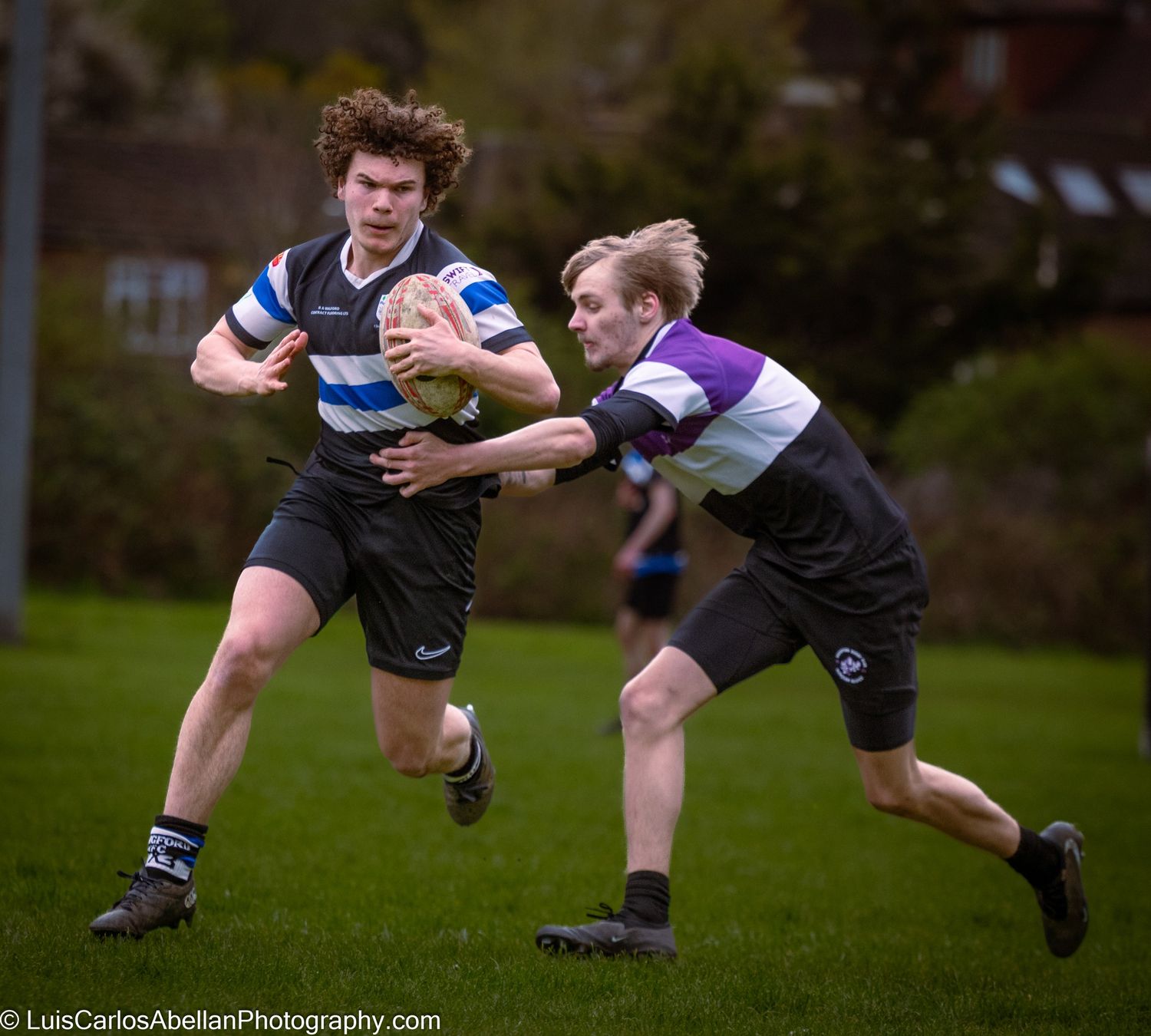 Rugby player running with the ball while being pursued by an opponent during a local match, photographed by Luis Carlos Abellan in Kent.