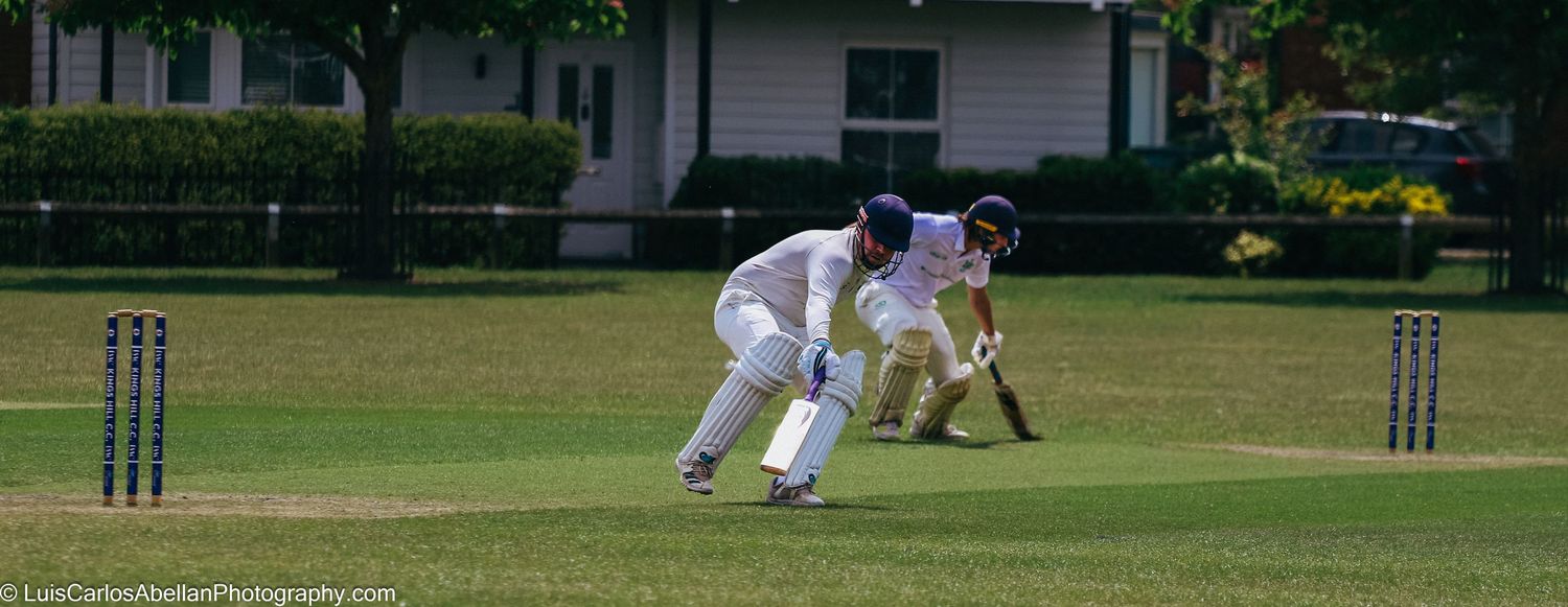 Two cricket batsmen taking a quick single between the wickets at Kings Hill Cricket Club, Kent. Sports photography by Luis Carlos Abellan.