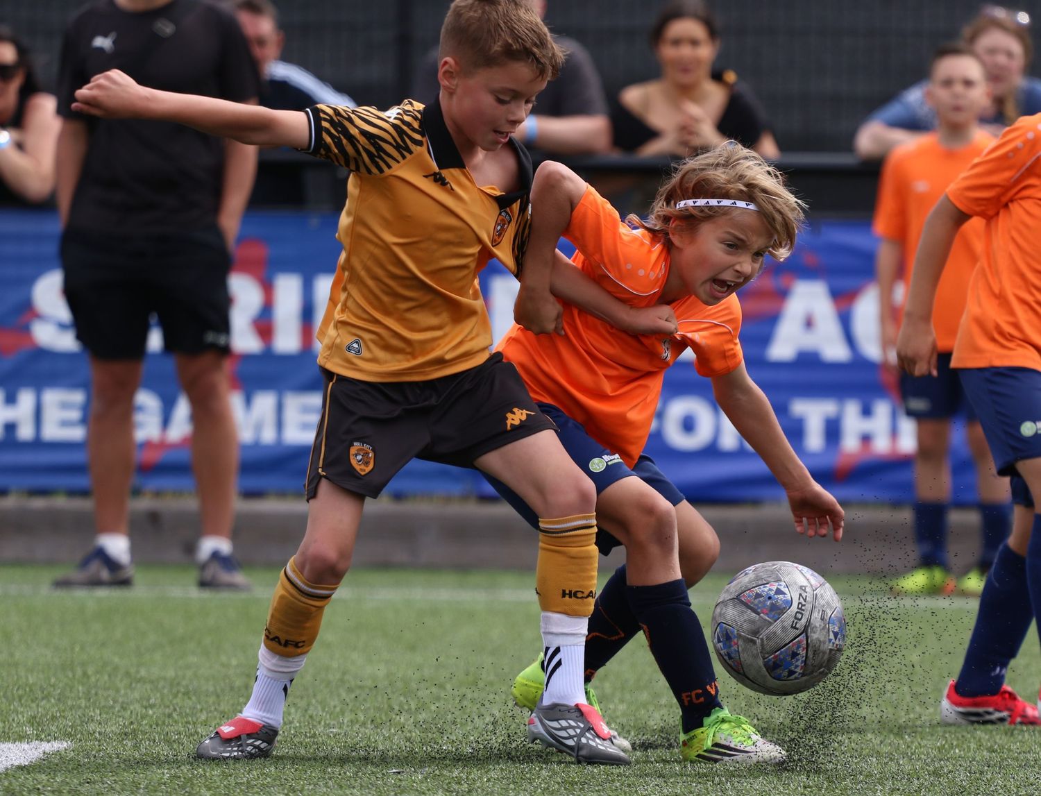 Two youth football players tackle for the ball during a match in Kent, captured by sports photographer Luis Carlos Abellan.