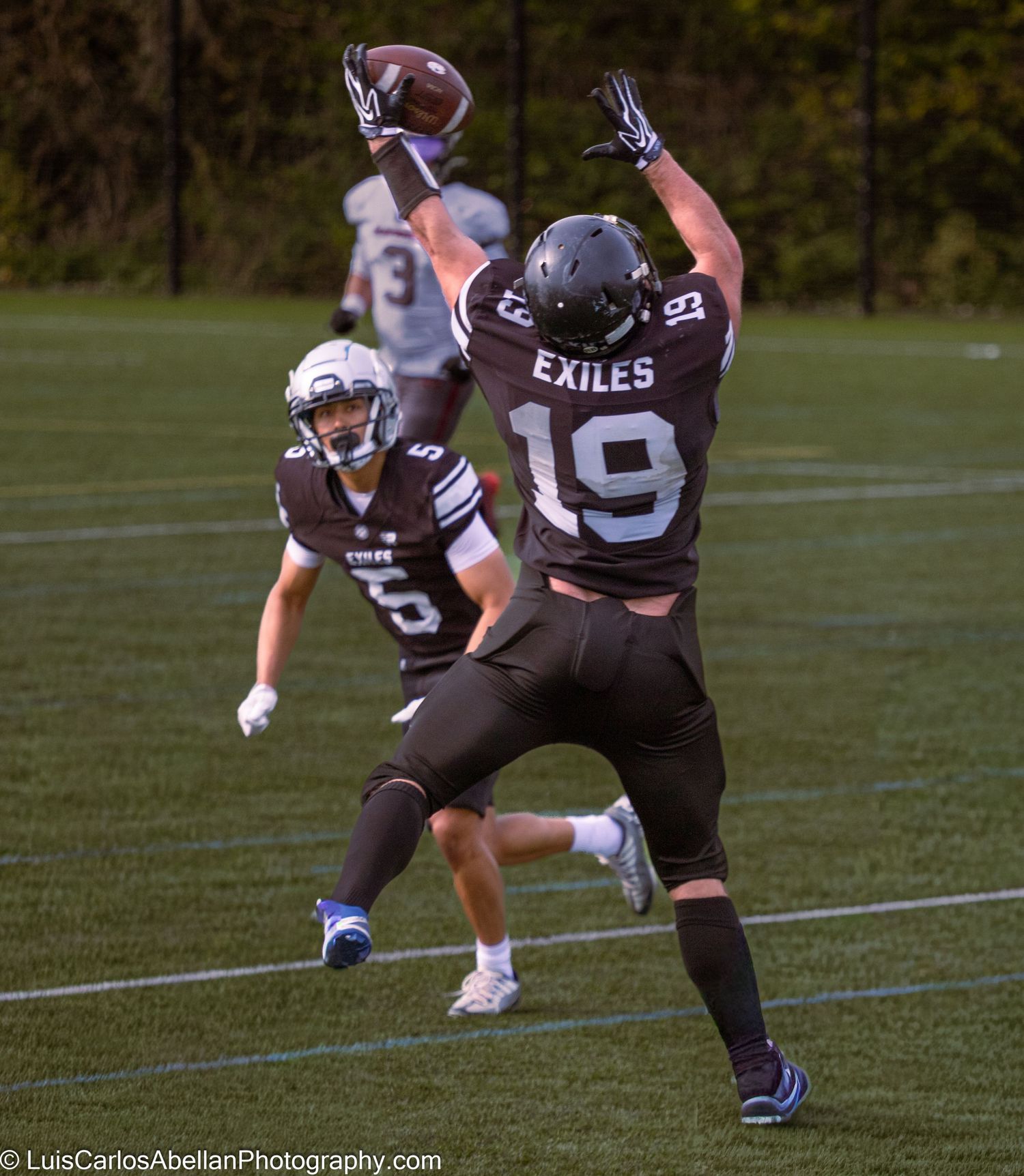 American football player number 19 from the Exiles leaping to make a catch during a game in England, photographed by Luis Carlos Abellan.