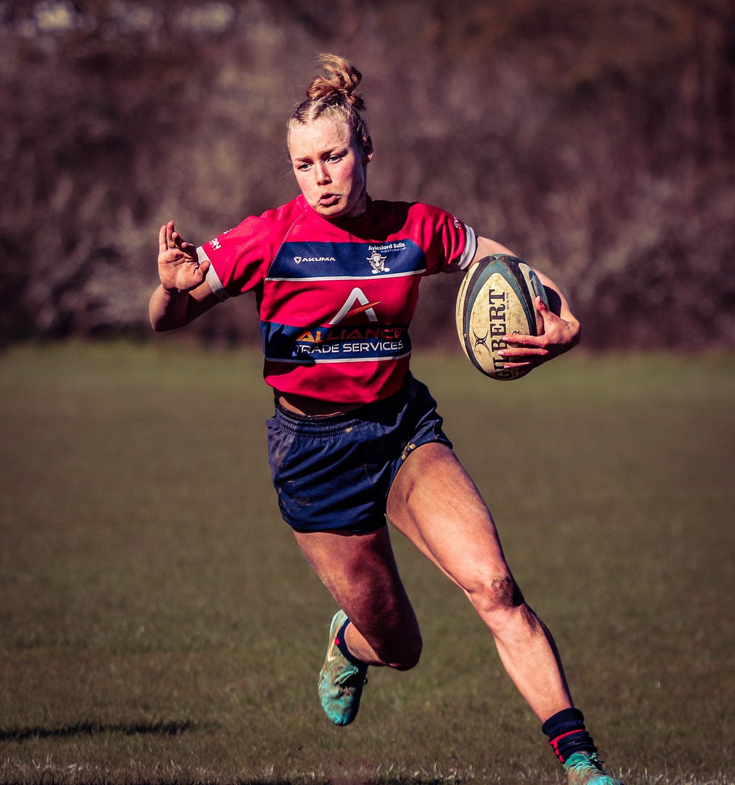 Female rugby player sprinting with the ball during a competitive match in the South East, captured by Luis Carlos Abellan Photography.
