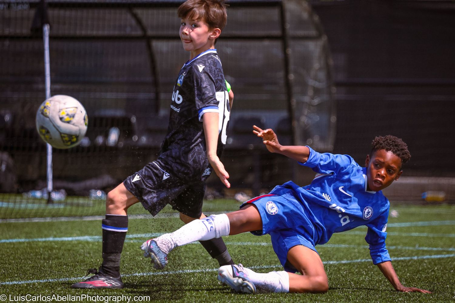 A youth football player executes a slide tackle during a match in Kent, filmed by Luis Carlos Abellan Photography.