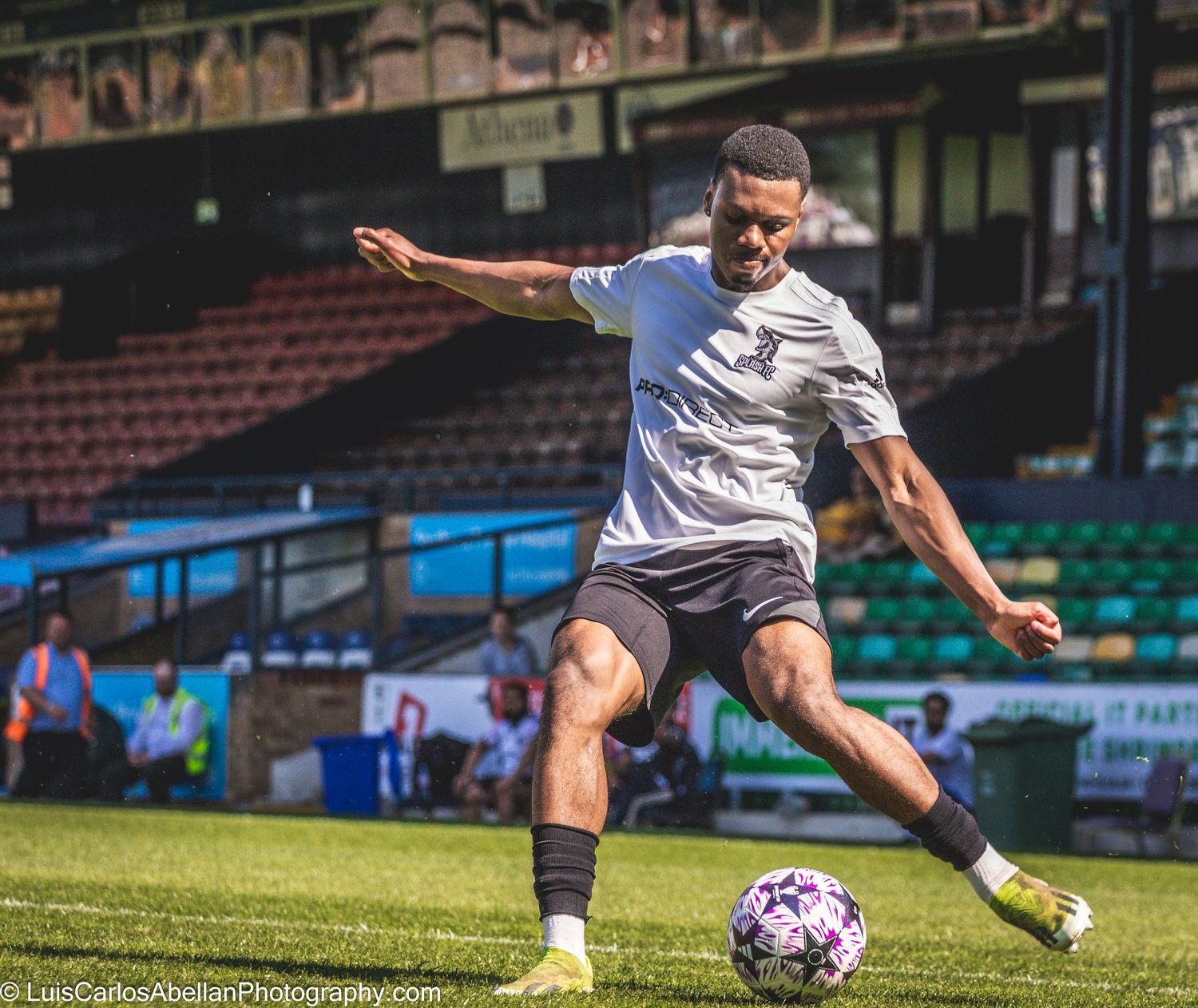 Footballer in white kit kicking the ball during a match in Kent, shot by sports photographer Luis Carlos Abellan Photography.