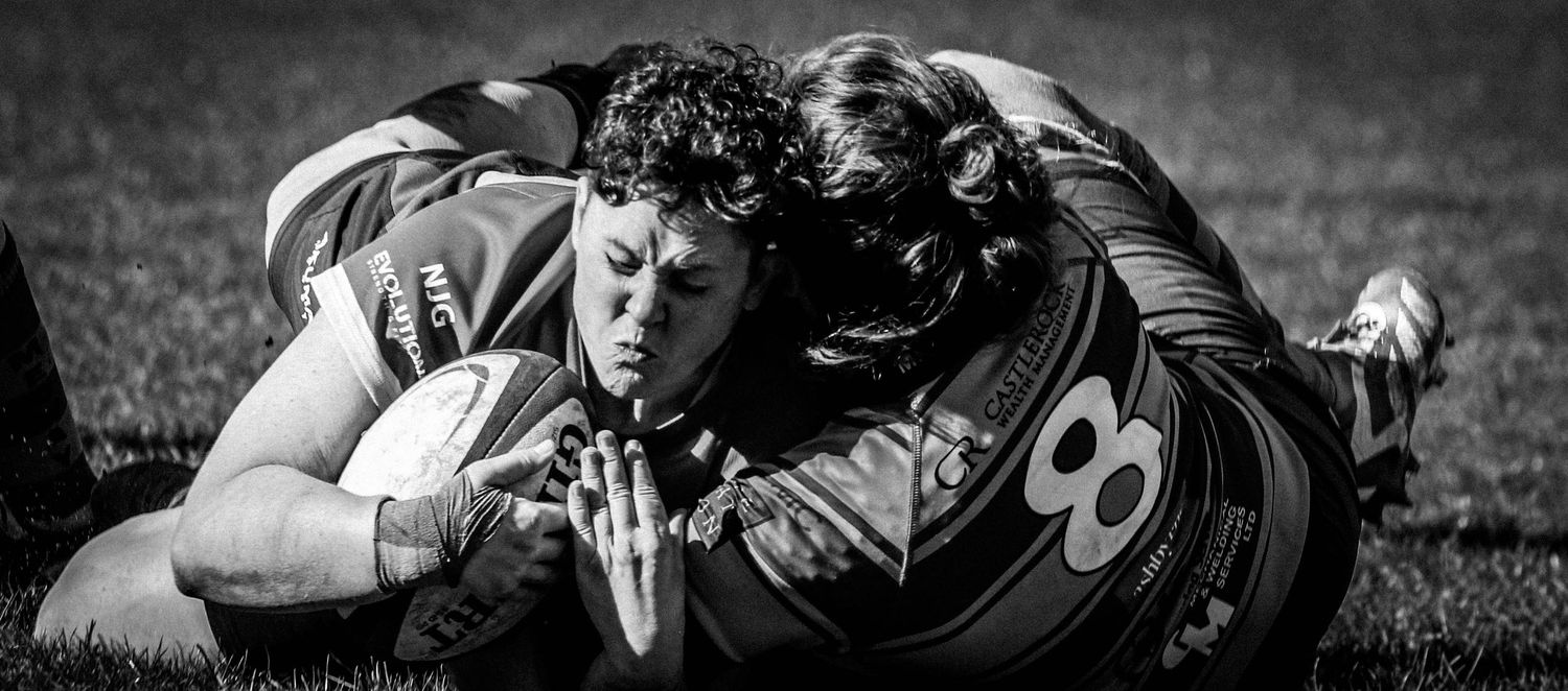 Black and white close-up action shot of a intense rugby tackle during a match in the South East, by Luis Carlos Abellan Photography.