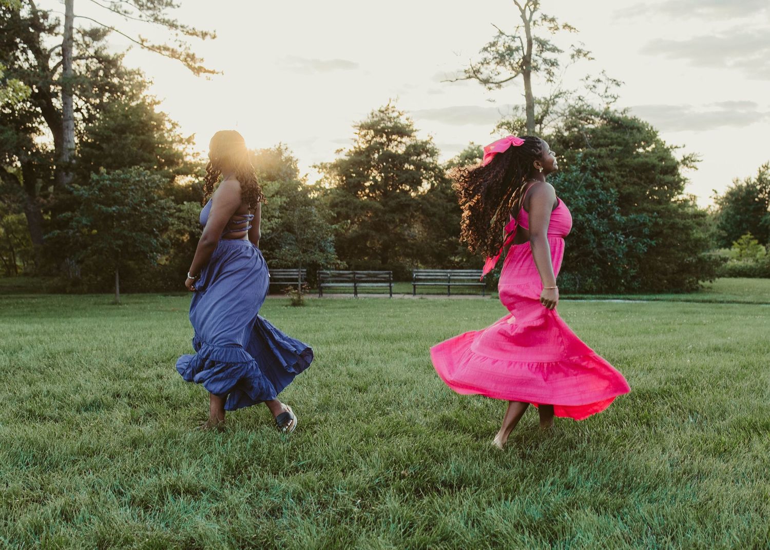 High School seniors in long flowy dresses in a field in Forest park in St. Louis MO for a senior session.