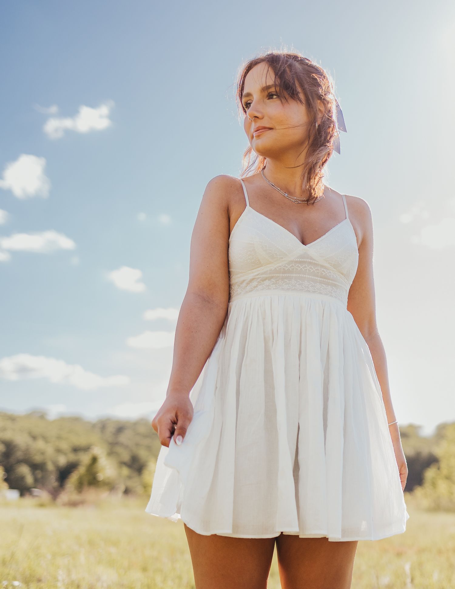 high school senior in a white dress in a field near Waynesville mo