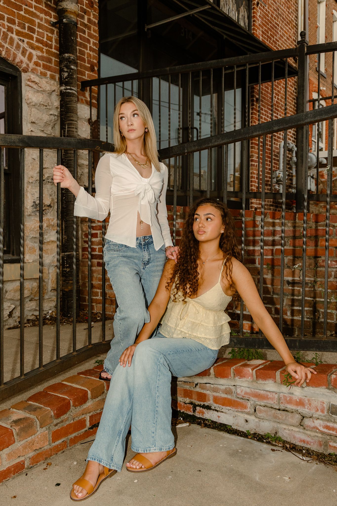 high school senior photos that are shot in downtown Springfield. one girl is wearing a white shirt and one girl is wear a yellow short and d